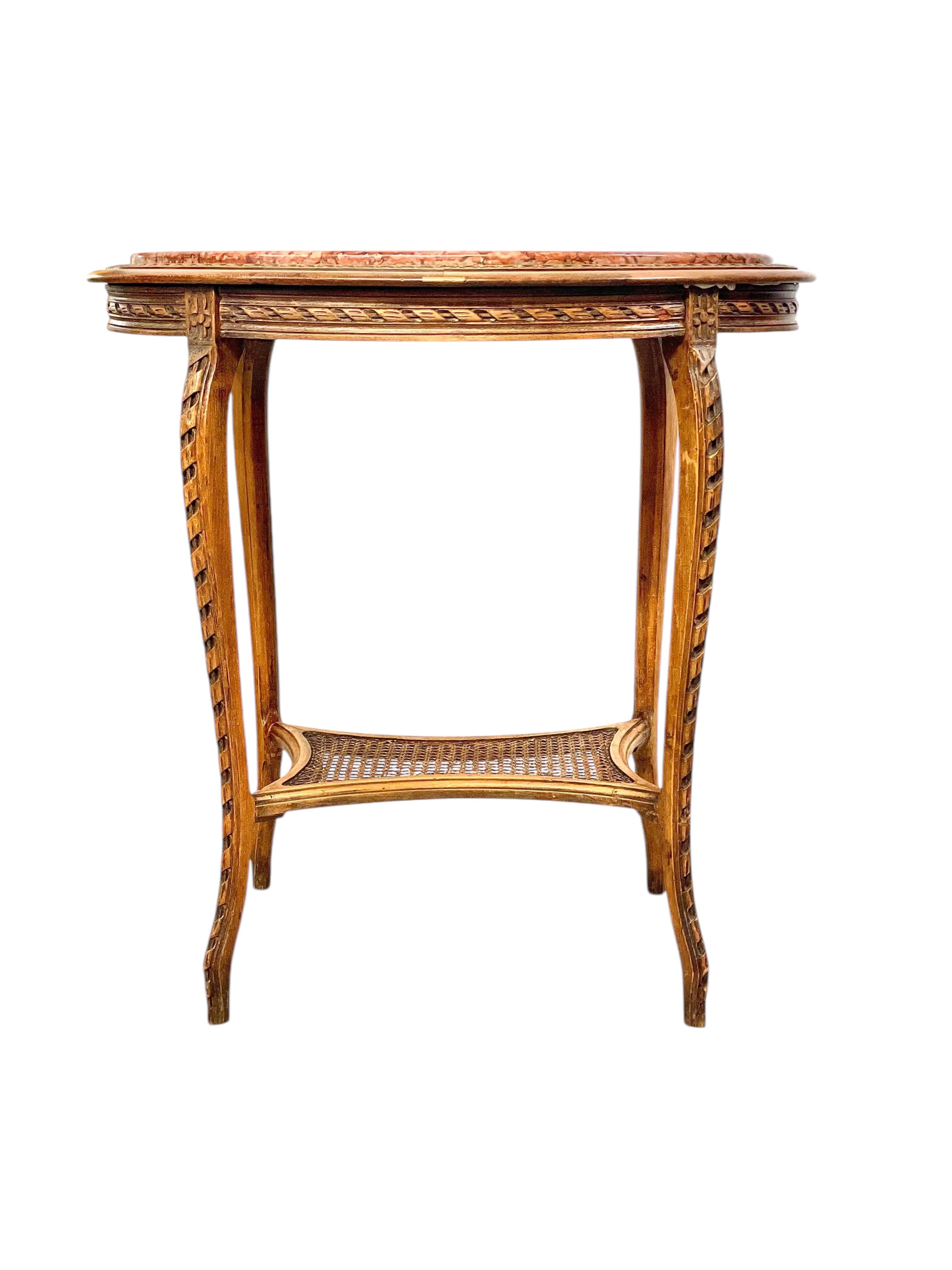 Questo squisito guéridon o tavolo da centro ovale del XIX secolo è realizzato in noce splendidamente intagliato, mettendo in mostra il calore naturale e l'eleganza di questo legno senza tempo. Il piano in marmo rosa, con le sue suggestive venature e