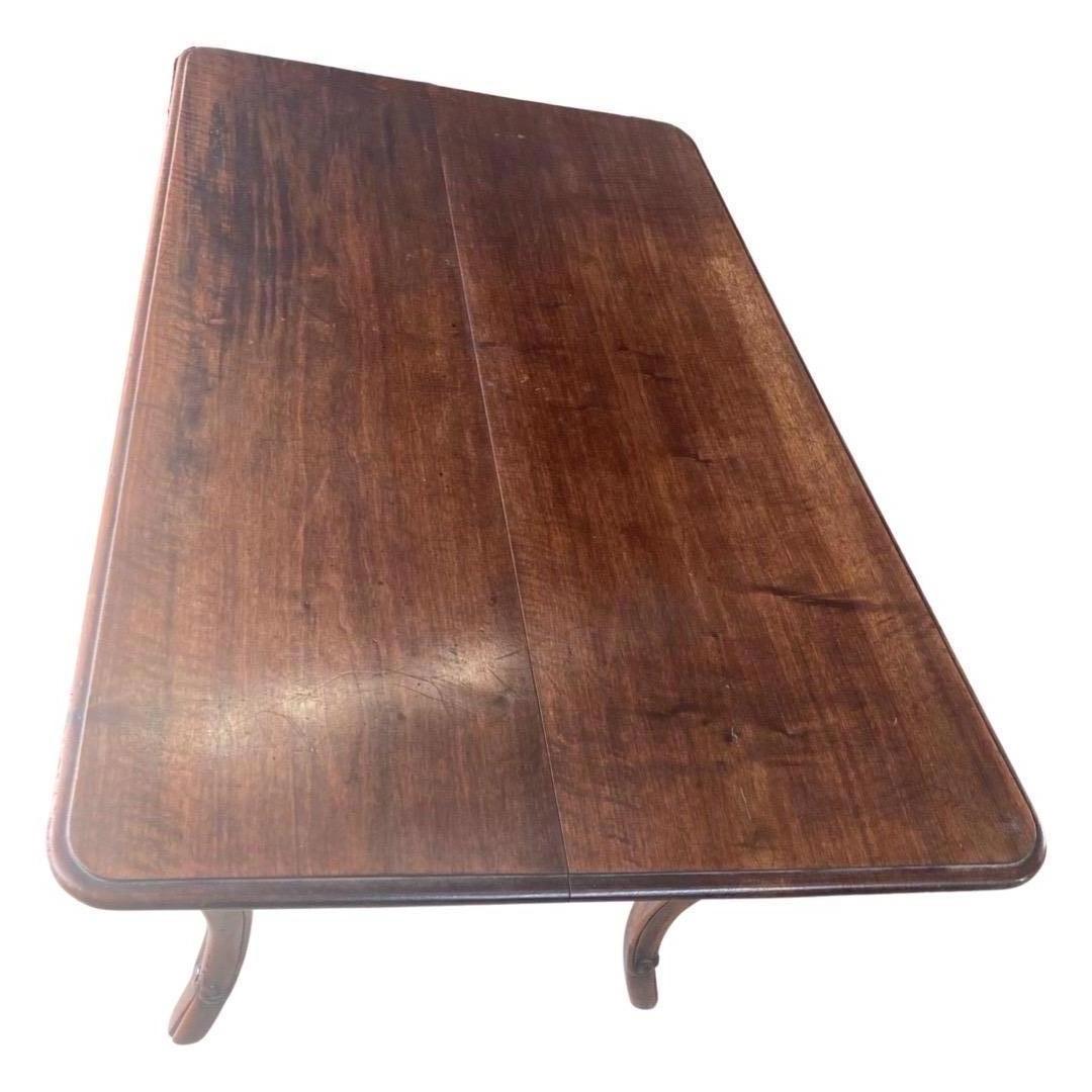 Kitchen table hand-made in France in the early 1800s using walnut. This is a very nice table with a relatively small footprint and large working surface. The top is made of two large boards with an ogee edge and rounded corners, and anchors to the
