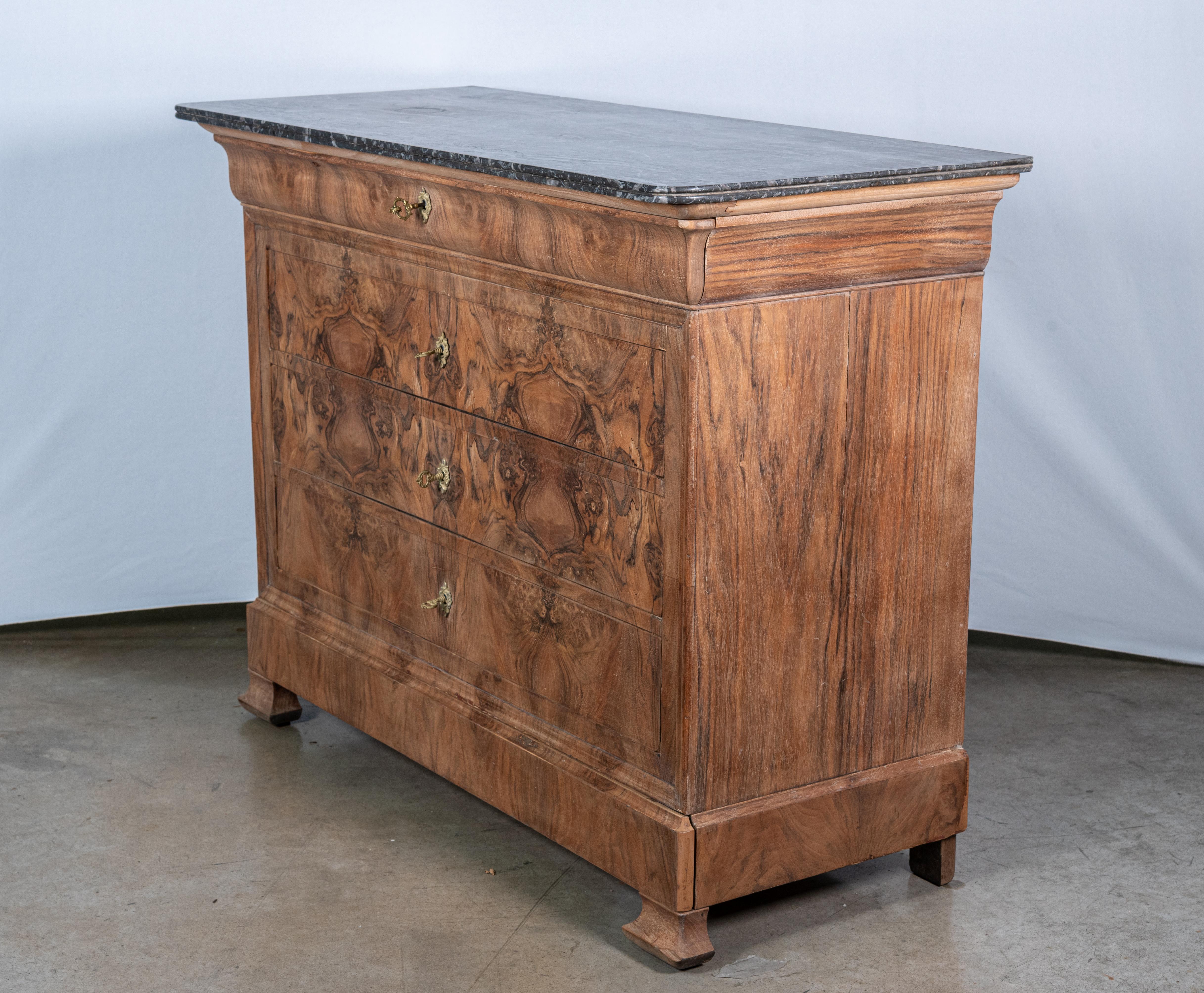 Indulge in the refined beauty of our 19th Century French Louis Philippe Walnut Commode, meticulously restored to its former glory. Crafted with premium walnut wood and adorned with captivating book-matched walnut veneer, this commode exudes timeless