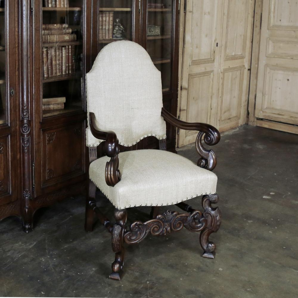 The artistry to which this handsome 19th century French Walnut Armchair was carved, when added to the newly installed neutral upholstery, makes this selection truly fit for a king! Styled in the manner of Louis XIV, its high, arched seatback and