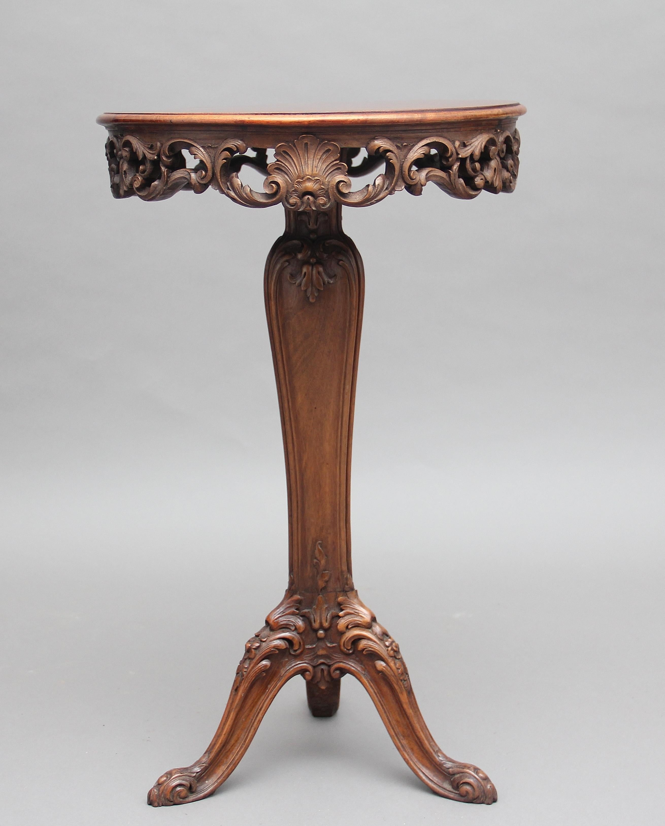 19th century French carved walnut occasional table, the circular top having a very ornate carved floral frieze including carved shell decoration, the top supported on a carved triform column terminating with three shaped and carved legs, circa