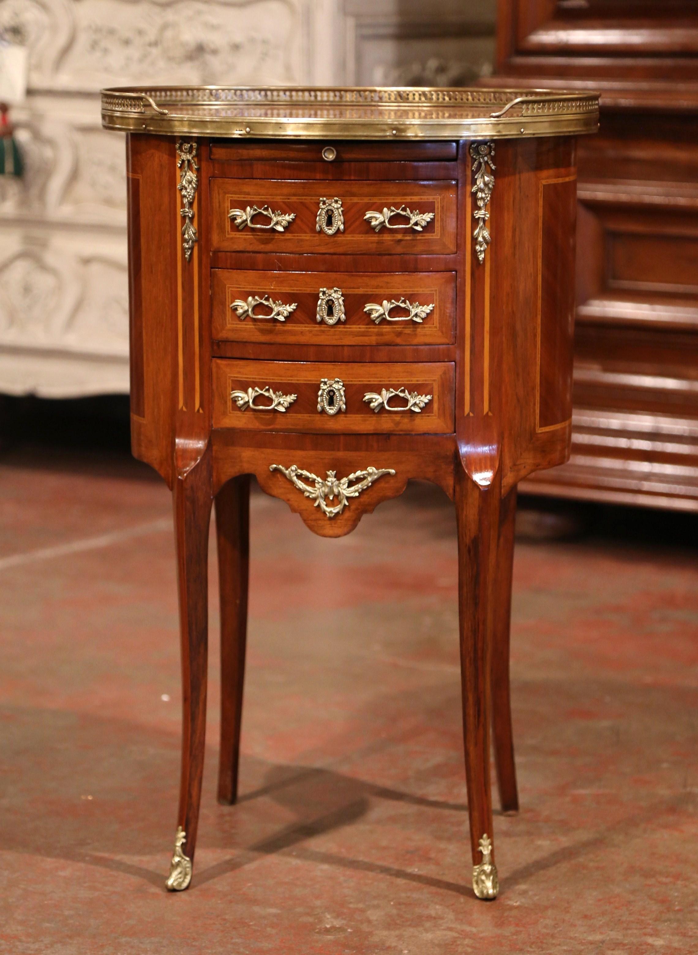 Crafted in Paris, France, circa 1890 and oval in shape, this elegant fruitwood petite commode stands on cabriole legs with front feet brass mounts, over a scalloped apron dressed with a decorative brass motif; the chest features three drawers across