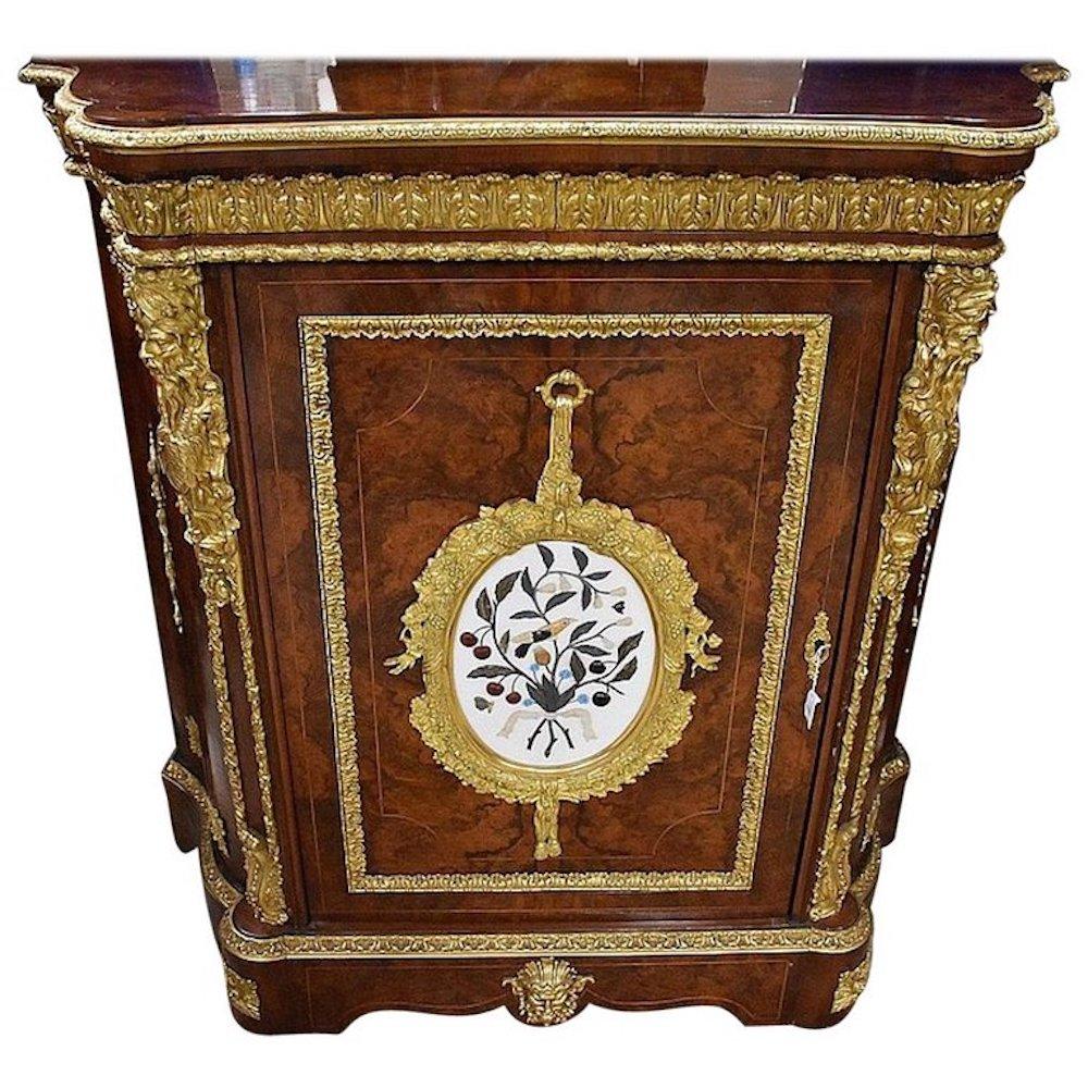 A museum-quality French 19th century single door bur walnut pier cabinet having magnificent Pietra Dura marble panel and all-over ormolu mounts.