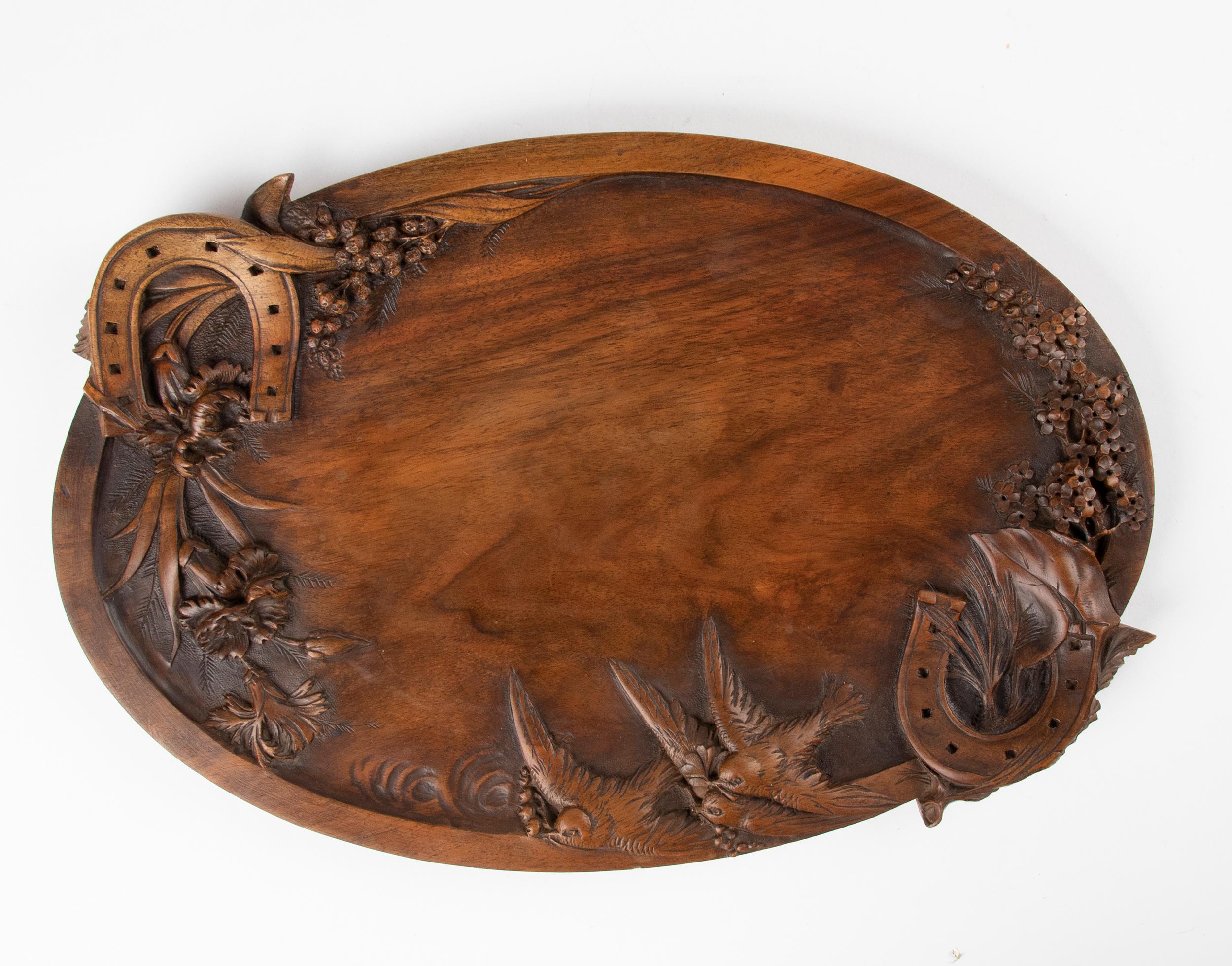 Beautiful antique tray with beautifully detailed carvings. The theme is so sweet, with the horseshoes symbolizing good luck and the swallows symbolizing love and freedom. This theme is common in French arts at the end of the 19th century. The wood