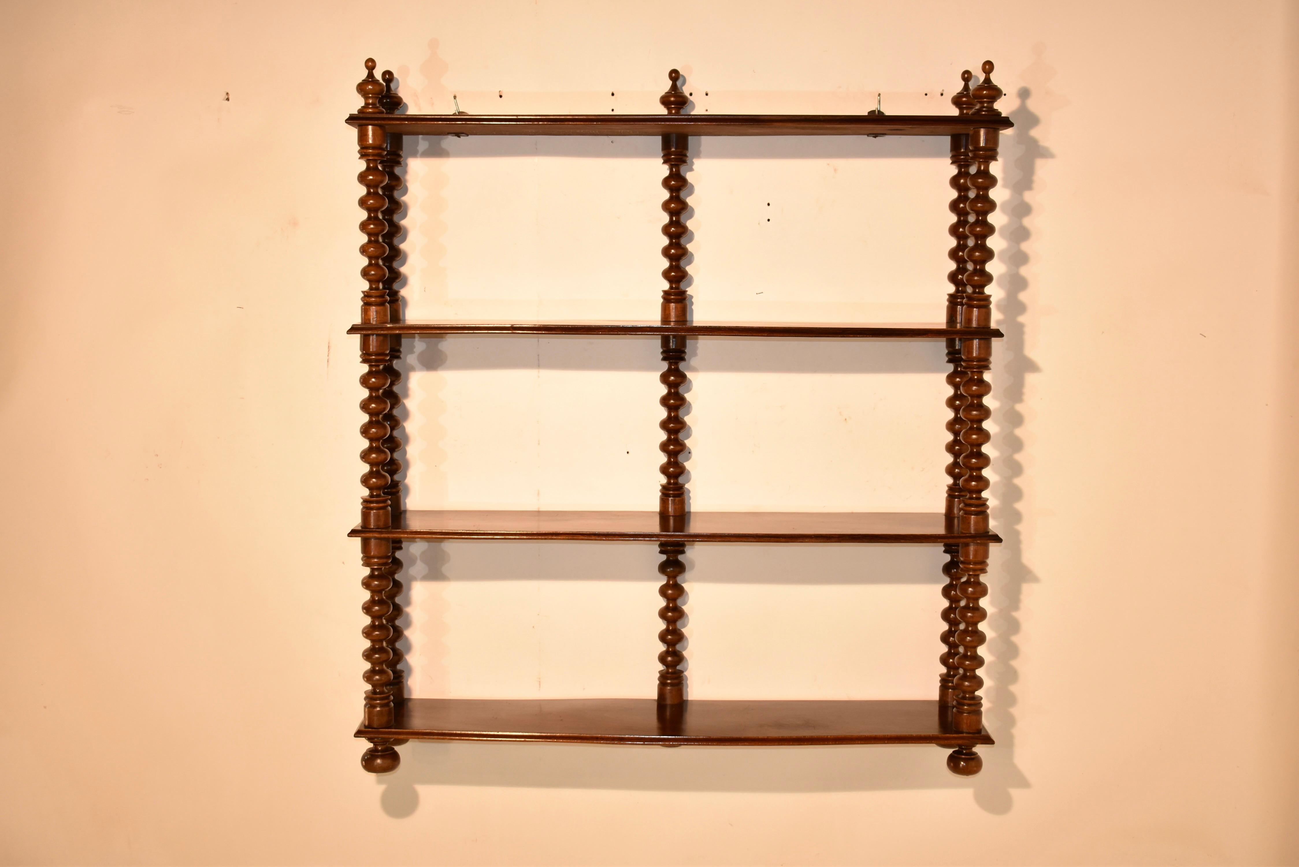 19th Century French standing shelf made from walnut. It has wonderfully hand turned finials at the top of the piece, over three shelves, all separated by hand turned shelf supports in a bobbin pattern. The piece is supported on lovely hand turned