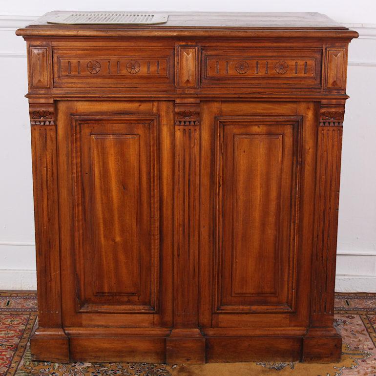 Unusual French walnut shop counter on wheels, nicely-finished on three sides with paneled construction and classical carved details and pilasters and with open adjustable shelves to the reverse with a single fitted upper drawer, the walnut top