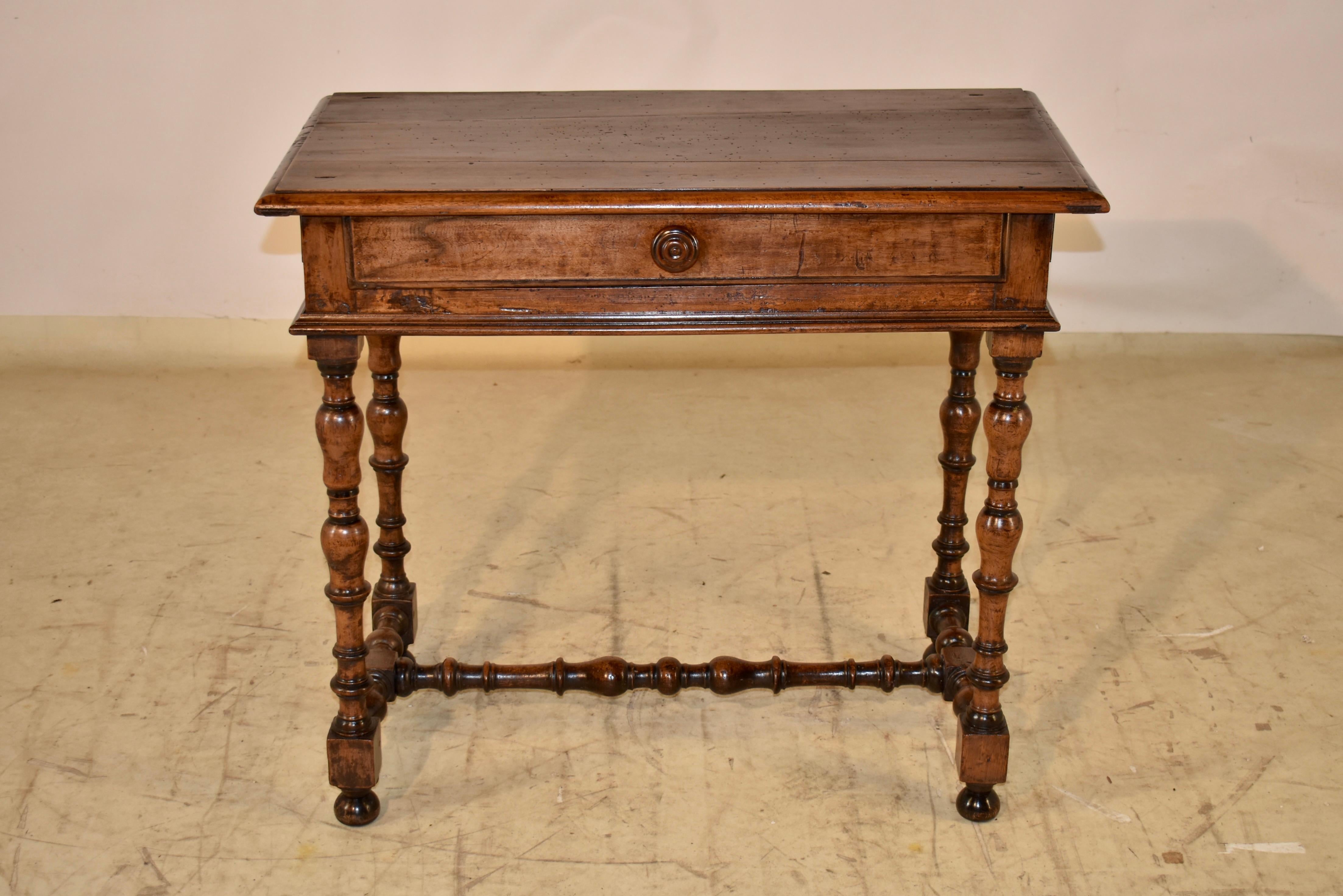 Table d'appoint en noyer du XIXe siècle provenant de France.  Le plateau est biseauté sur le pourtour et descend jusqu'aux côtés simples avec des panneaux en relief appliqués, et un seul tiroir à l'avant, qui a un bord biseauté.  La table repose sur
