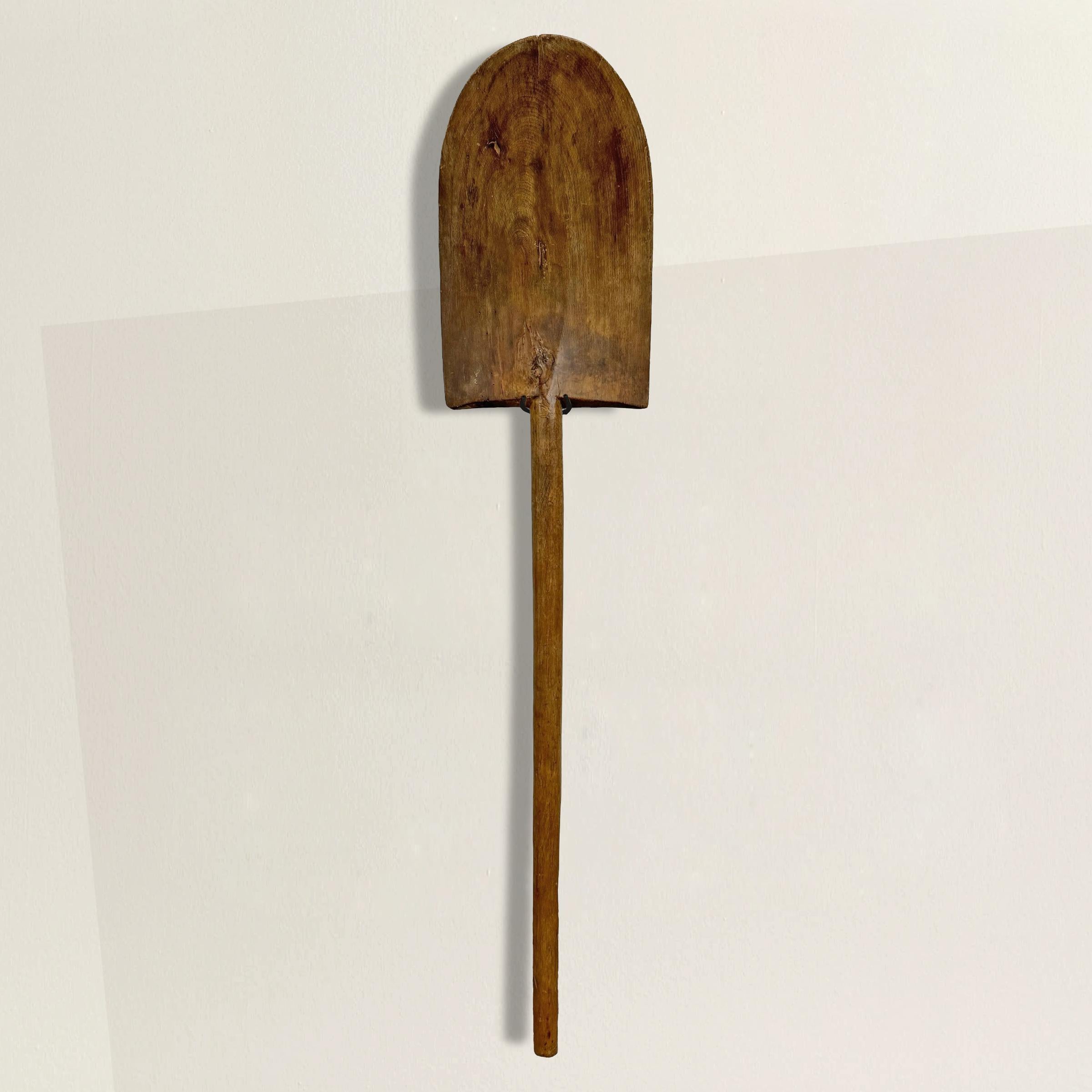 This 19th-century French hand-carved wood walnut garden spade is a stunning testament to craftsmanship and industry from a bygone era. Its beautifully aged walnut wood bears a remarkable, glowing patina, a testament to years of use and care.

Once