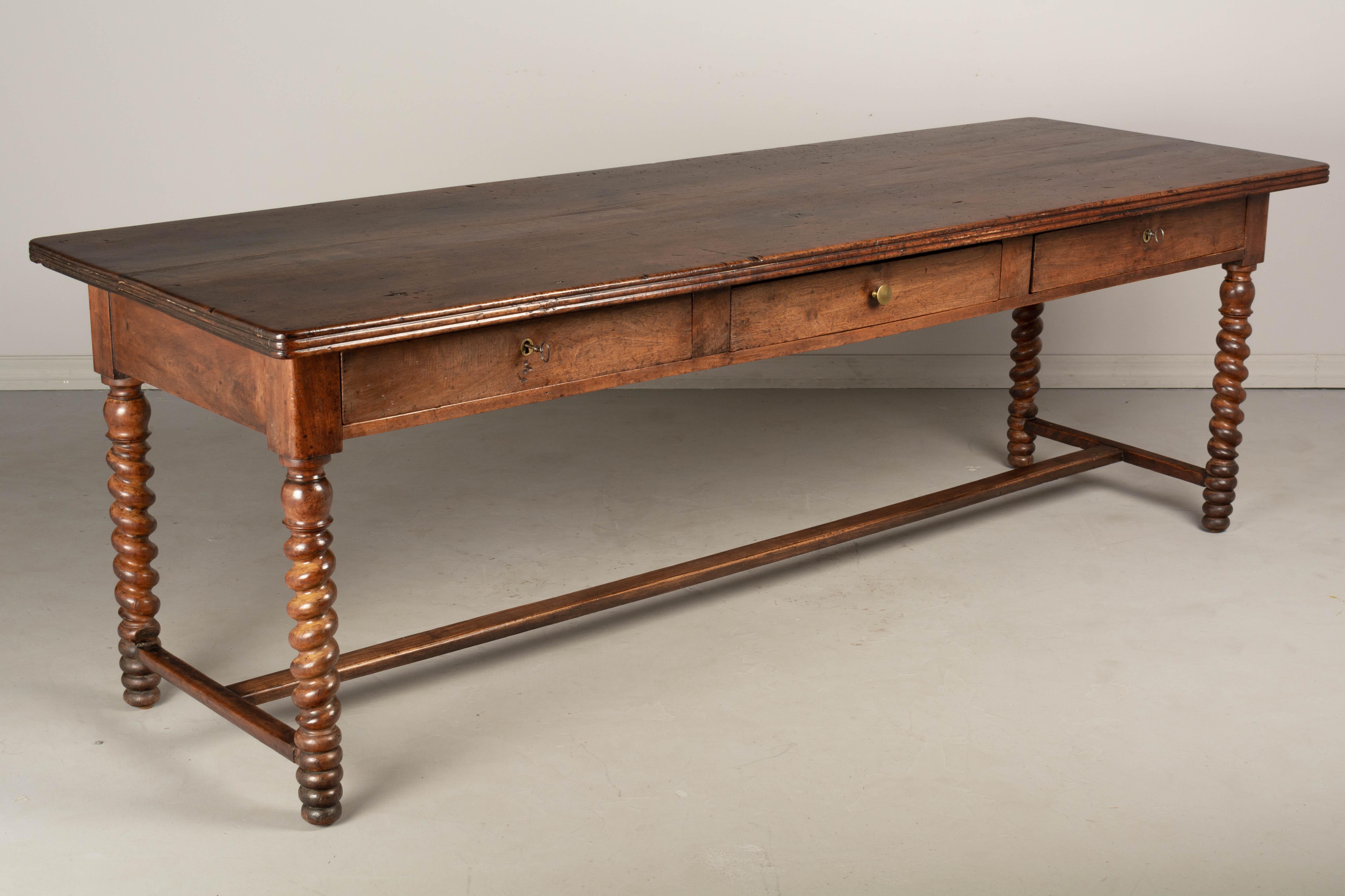A 19th century Louis Philippe style French table de drapier or draper's table, made of solid walnut. The top is made from three 1.5