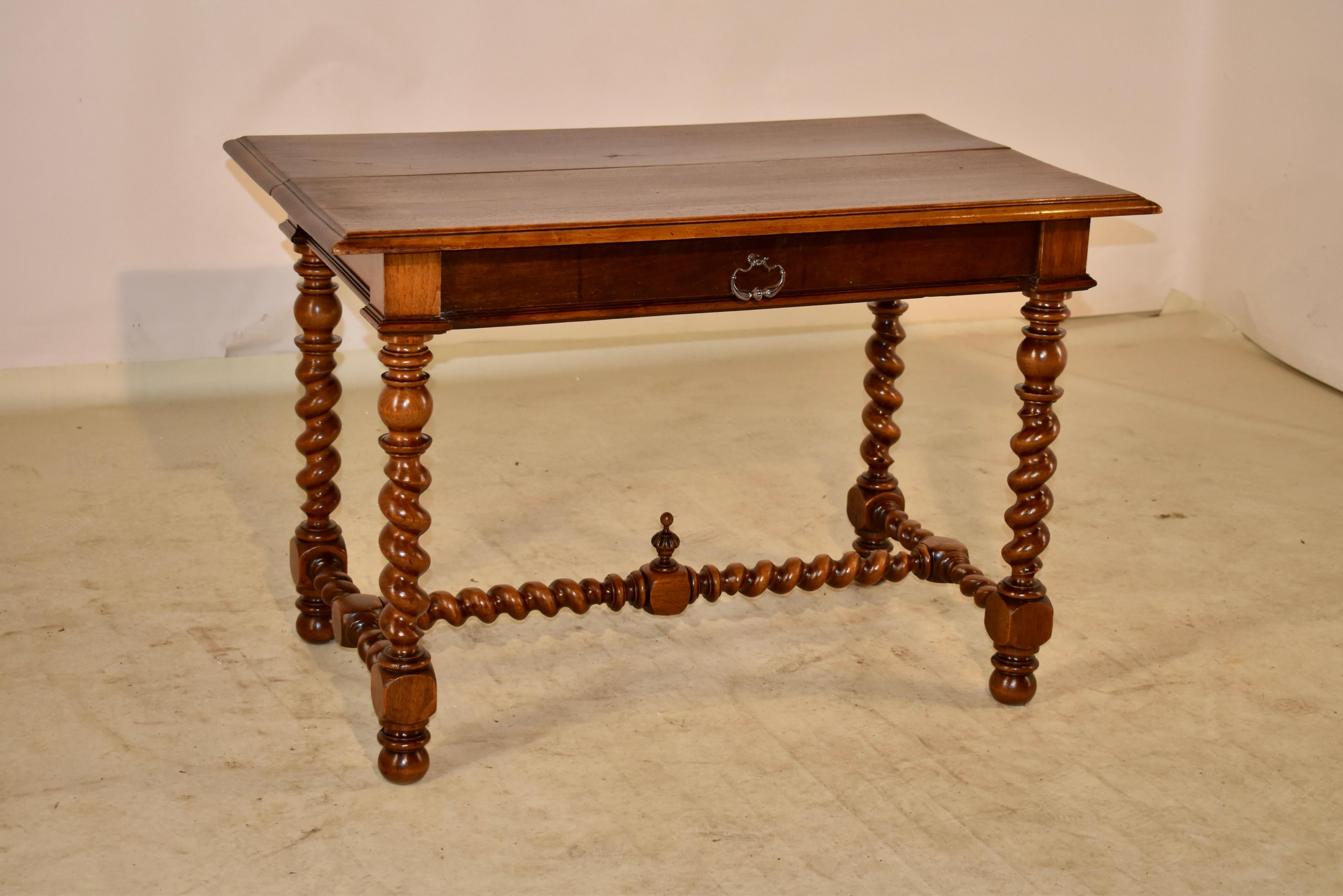 19th Century walnut table from France with a beautifully grained top with a beveled edge, following down to a simple apron containing a single drawer in the front. The table is finished on all four sides for easy placement in any room. the table is