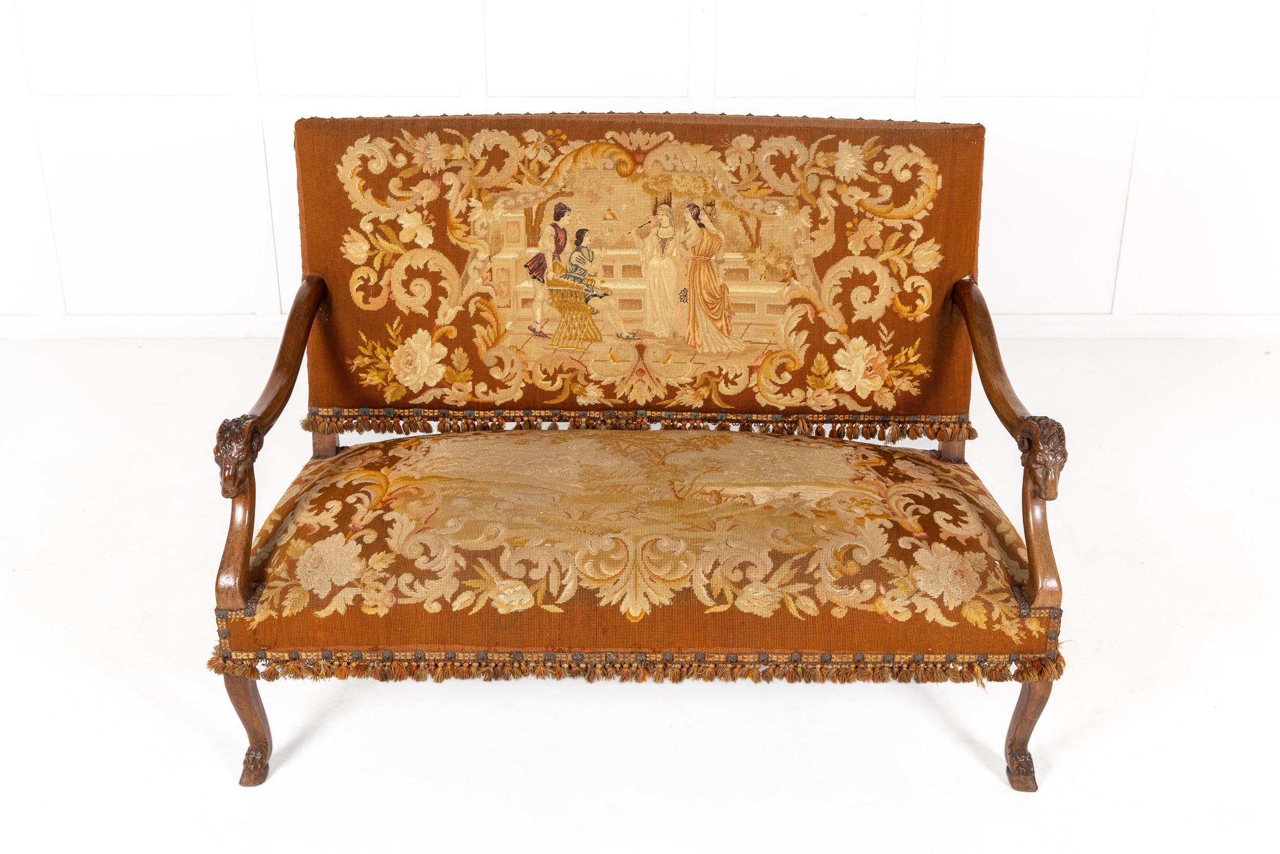 A bright and colourful 19th century French walnut sofa of good classic design with fabulous decorative needlepoint tapestry fabric depicting five characters in conversation. Having a generous padded seat with similar designs and braided tassels