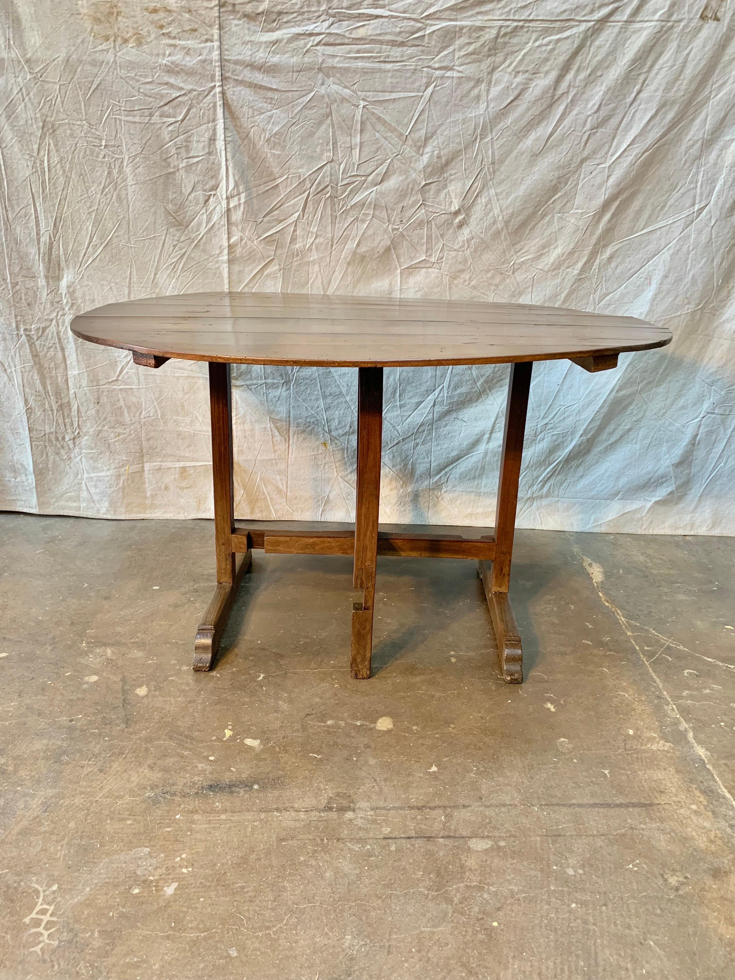 French wine tasting table, also known as a vendage or vigeron table, which was once used in the vineyards of France for tasting wine or enjoying a meal. This table would be suitable for use as a side table or in a wine cellar. Featuring a tilt-top,
