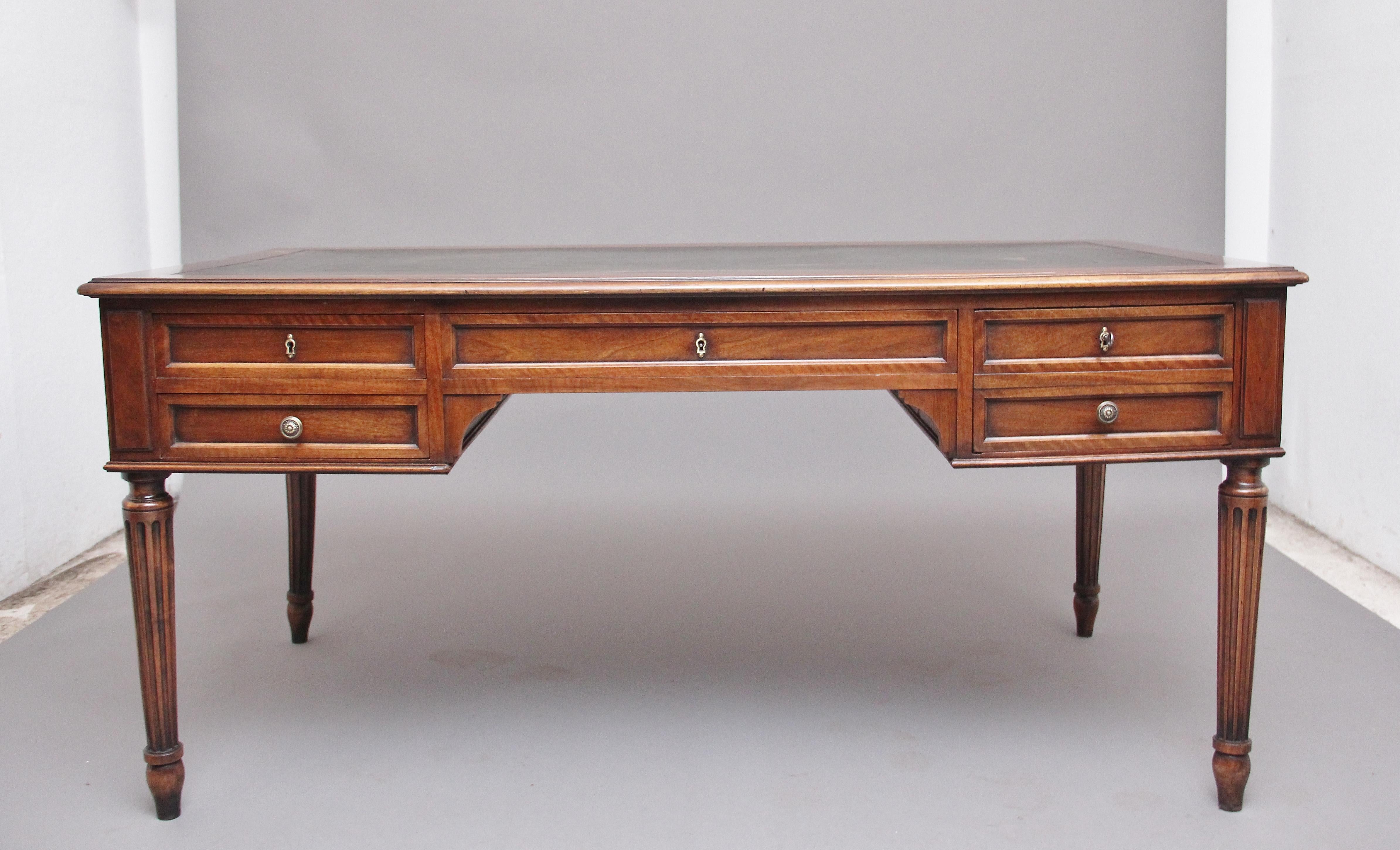19th century French walnut writing table, the moulded edge top having a green leather writing surface decorated with gold and blind tooling, each end of the table having pull out slides, the front of the table there are a combination of four oak