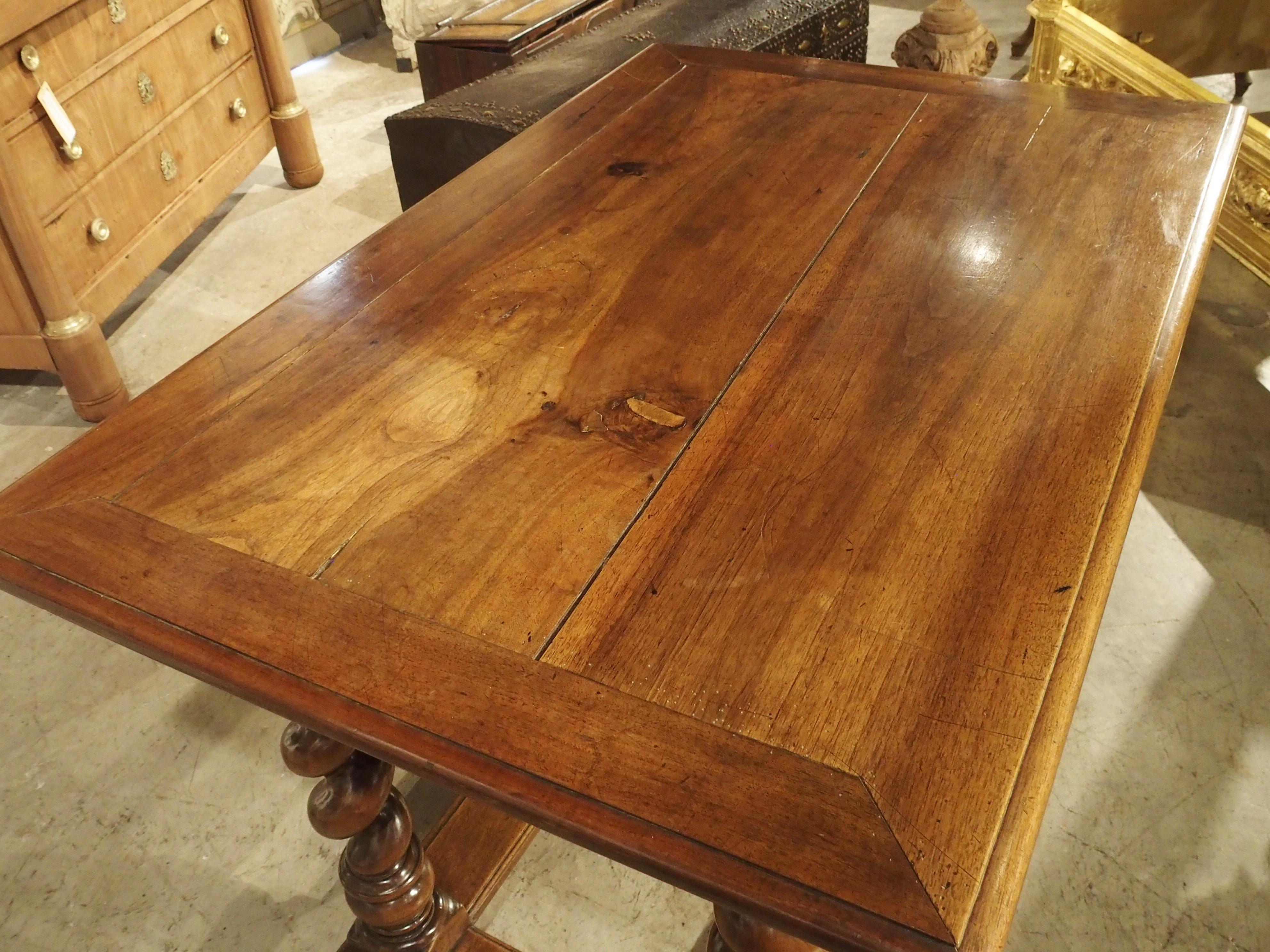 Hand-carved in France in the 1800’s, this walnut writing table is in the style of Louis XIII. Furniture from this period was quite often made from walnut wood. Turned legs were prevalent, but the wood adjacent to stretchers and aprons were often