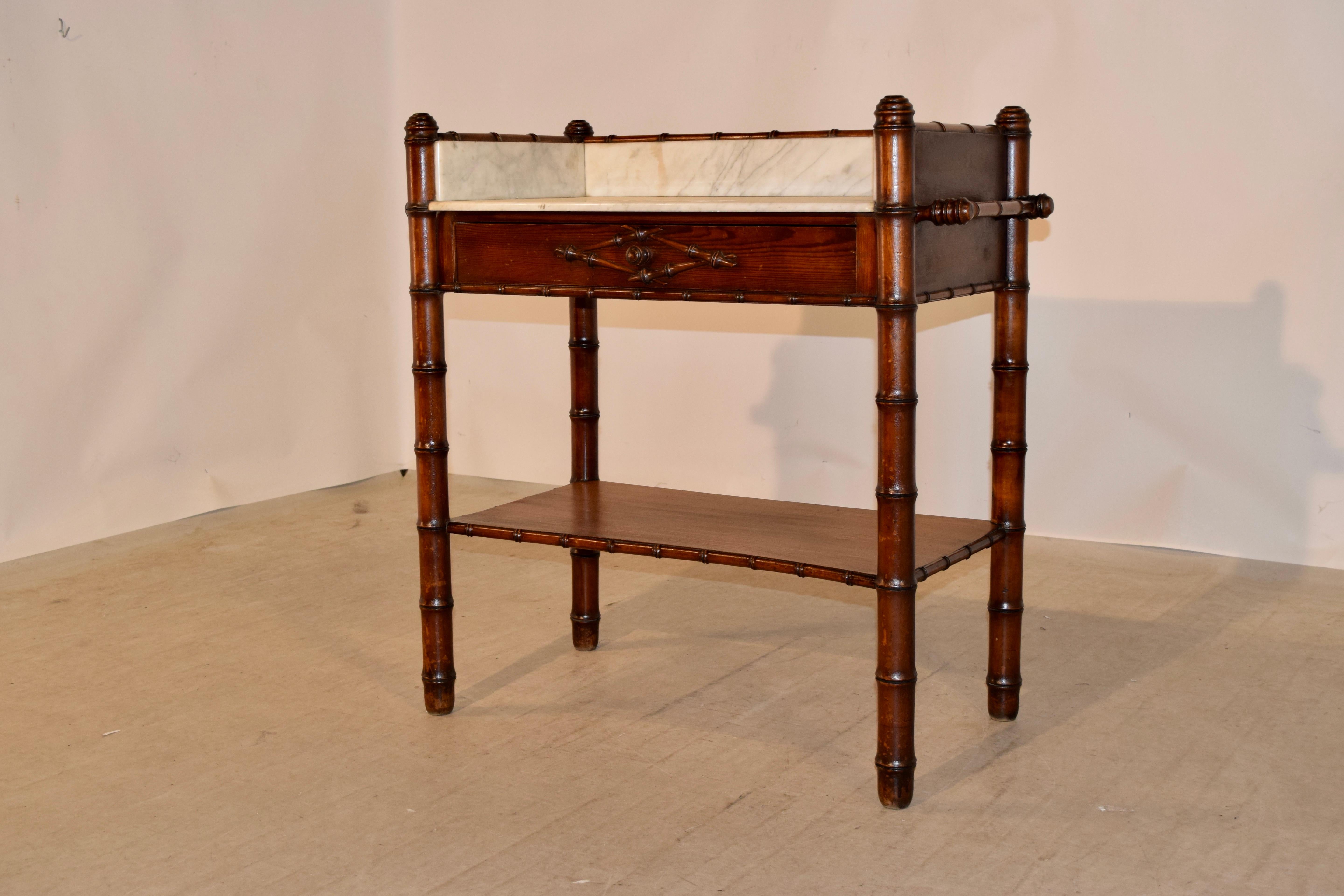 19th century French wash stand made from cherry and pitch pine. The top is made from marble and has a gallery around the back and sides. The sides have hand-turned towel rails and the front contains a single drawer. The legs are hand turned in the