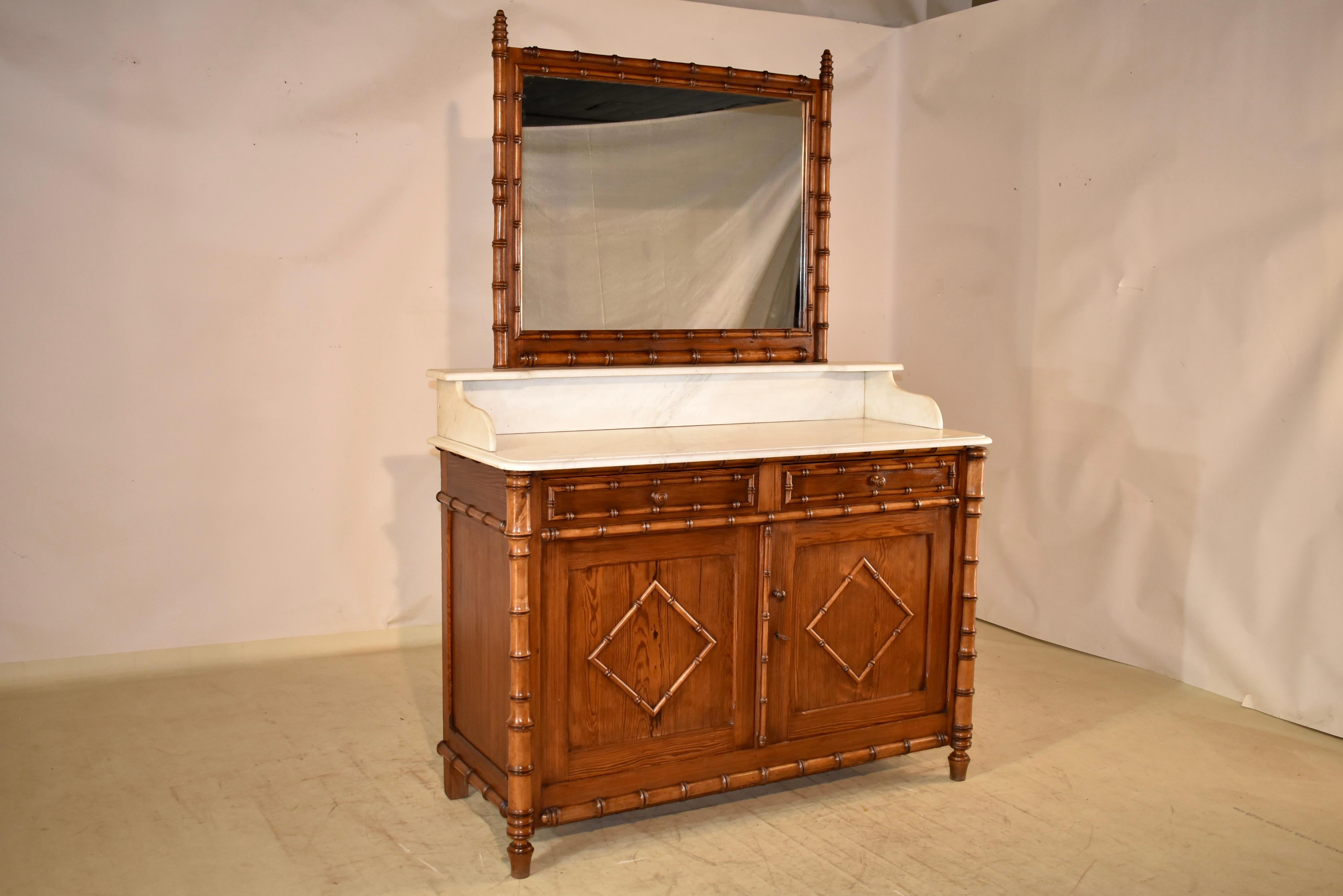 19th century faux bamboo wash stand from France with the original attached mirror, framed by gorgeous faux bamboo molded framing, sitting atop a marble shelf, which is supported on marble brackets on a Carrara marble top.  The counter height is