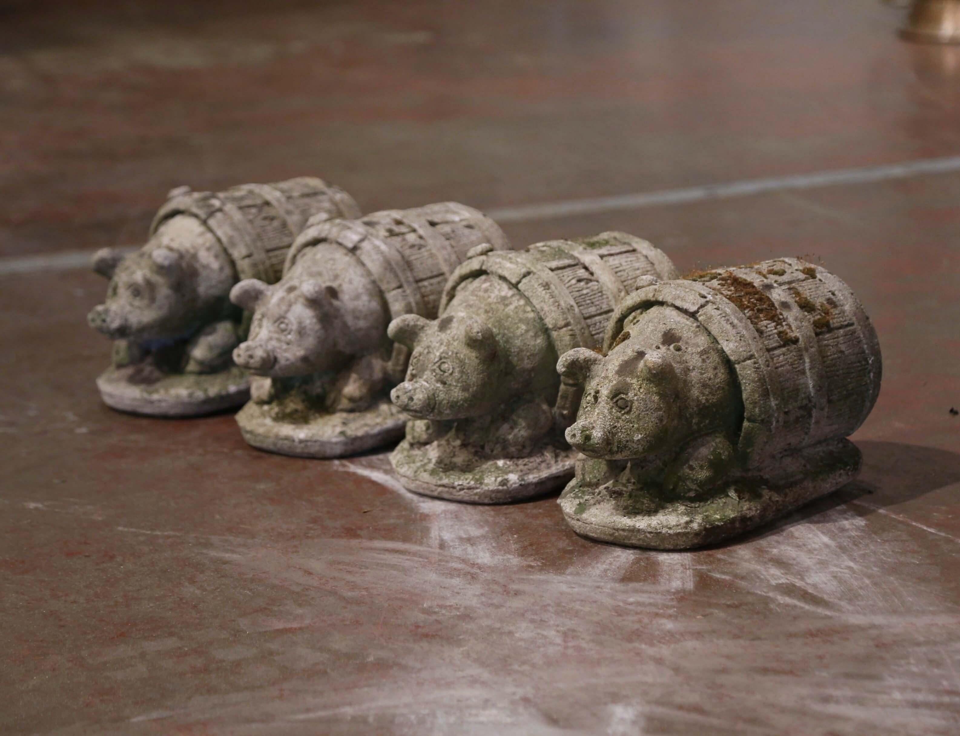 Decorate a patio or garden with this set of antique pig sculpture compositions. Crafted in France circa 1880 and carved of concrete, each sculpture features a pig resting inside a barrel. The cheerful pig compositions are in excellent condition and