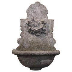19th Century French Weathered Stone Wall Fountain with Cherub Decor