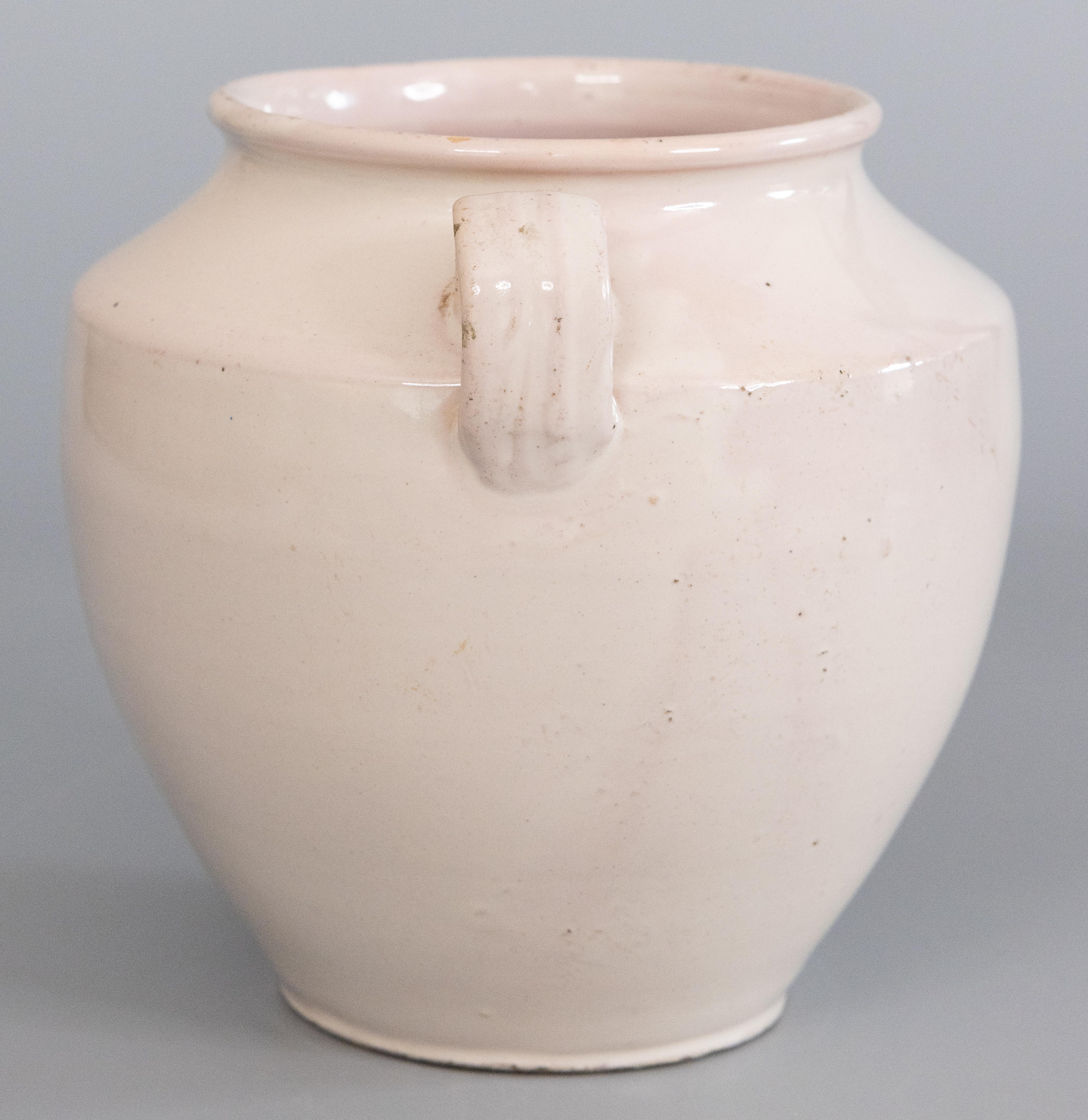 A lovely 19th-century French white glazed confit pot or jar. This pot is full of character, hand thrown and glazed with two charming handles, known as 'ears'. It is a creamy white with pink undertones and subtle variations. These jars were used for