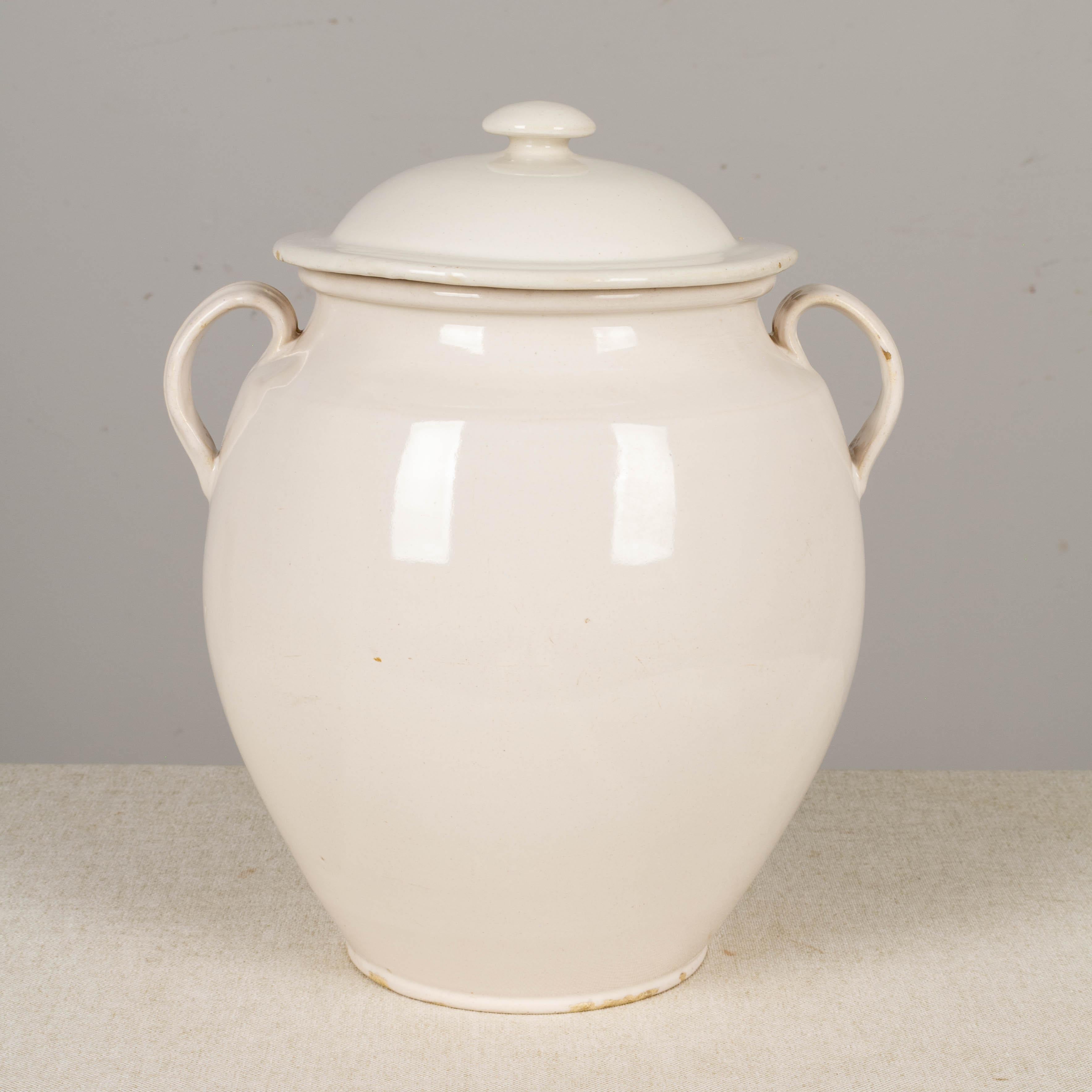 A 19th century French earthenware lidded confit pot with rare white terre de fer, or ironstone glaze from Martres-Tolosone, a small village in Southwest France. In very good condition with only a minor chip to the underside of the lid. This ordinary