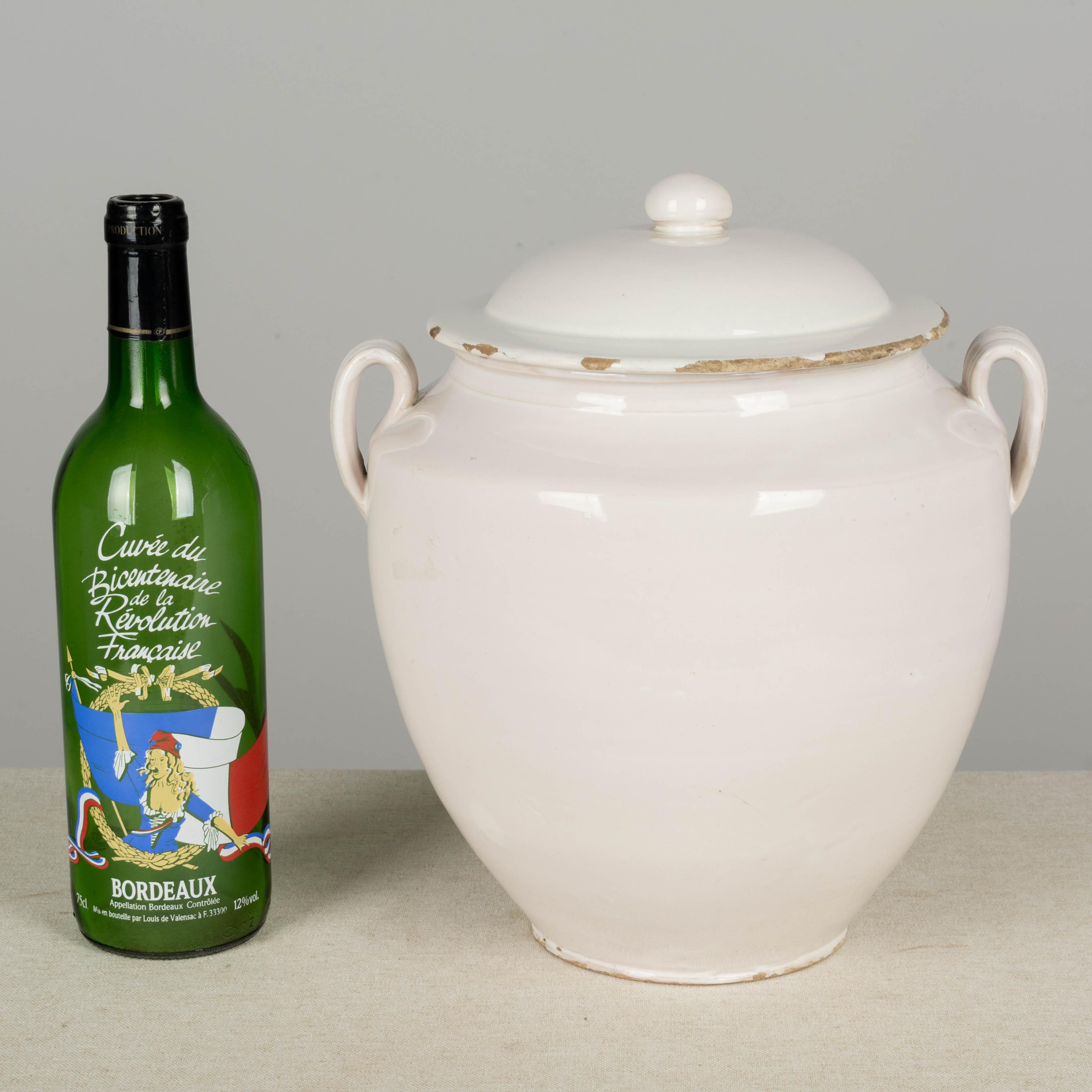 A 19th century French earthenware lidded confit pot with rare white terre de fer, or ironstone glaze from Martres-Tolosone, a small village in Southwest France. In good condition with a minor chips to rim and the underside of the lid. This ordinary