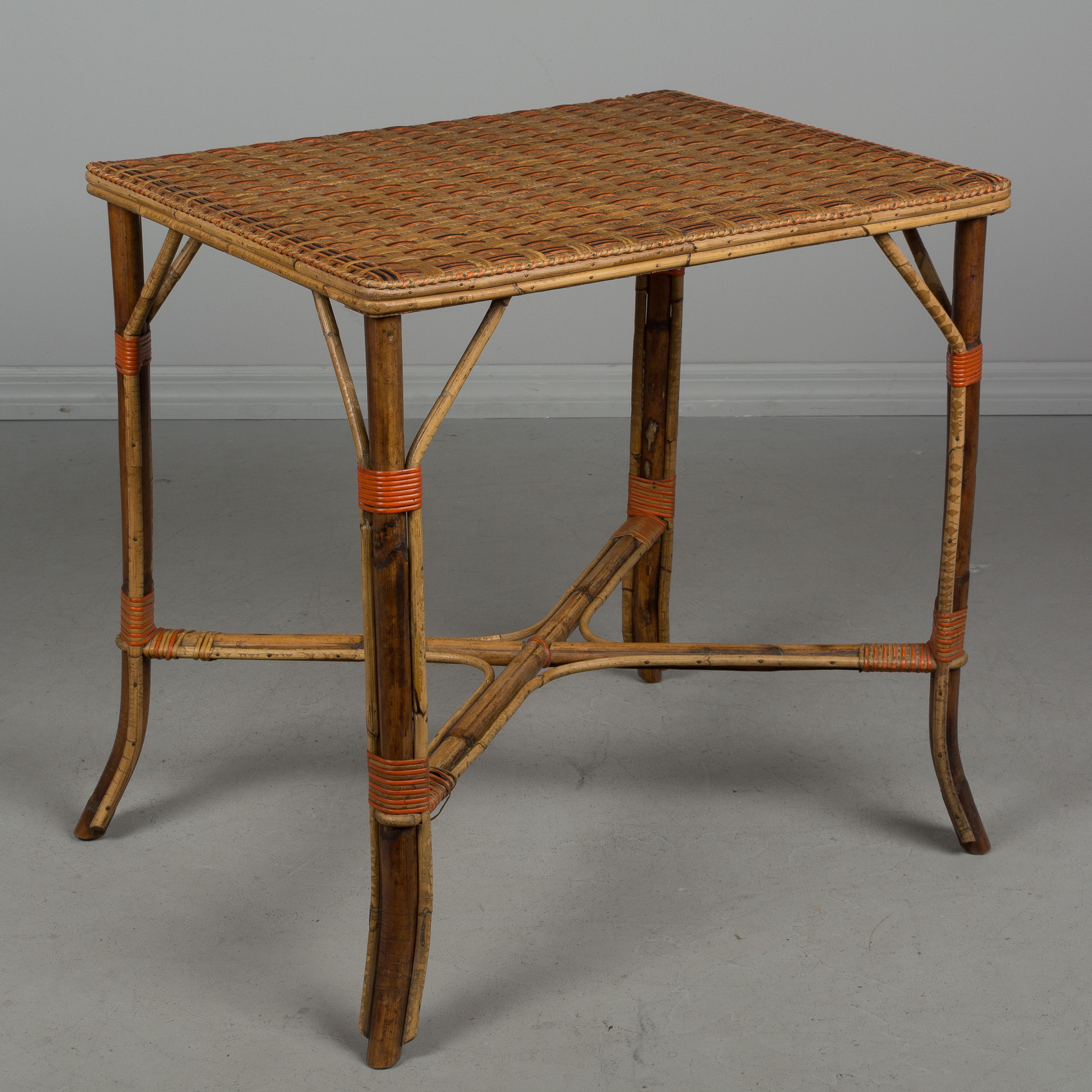 An early 19th century French woven wicker rattan dining set including a small rectangular table, two armchairs and two side chairs. Exceptional craftsmanship and design, having sturdy bamboo frames with x-pattern stretchers and tightly woven