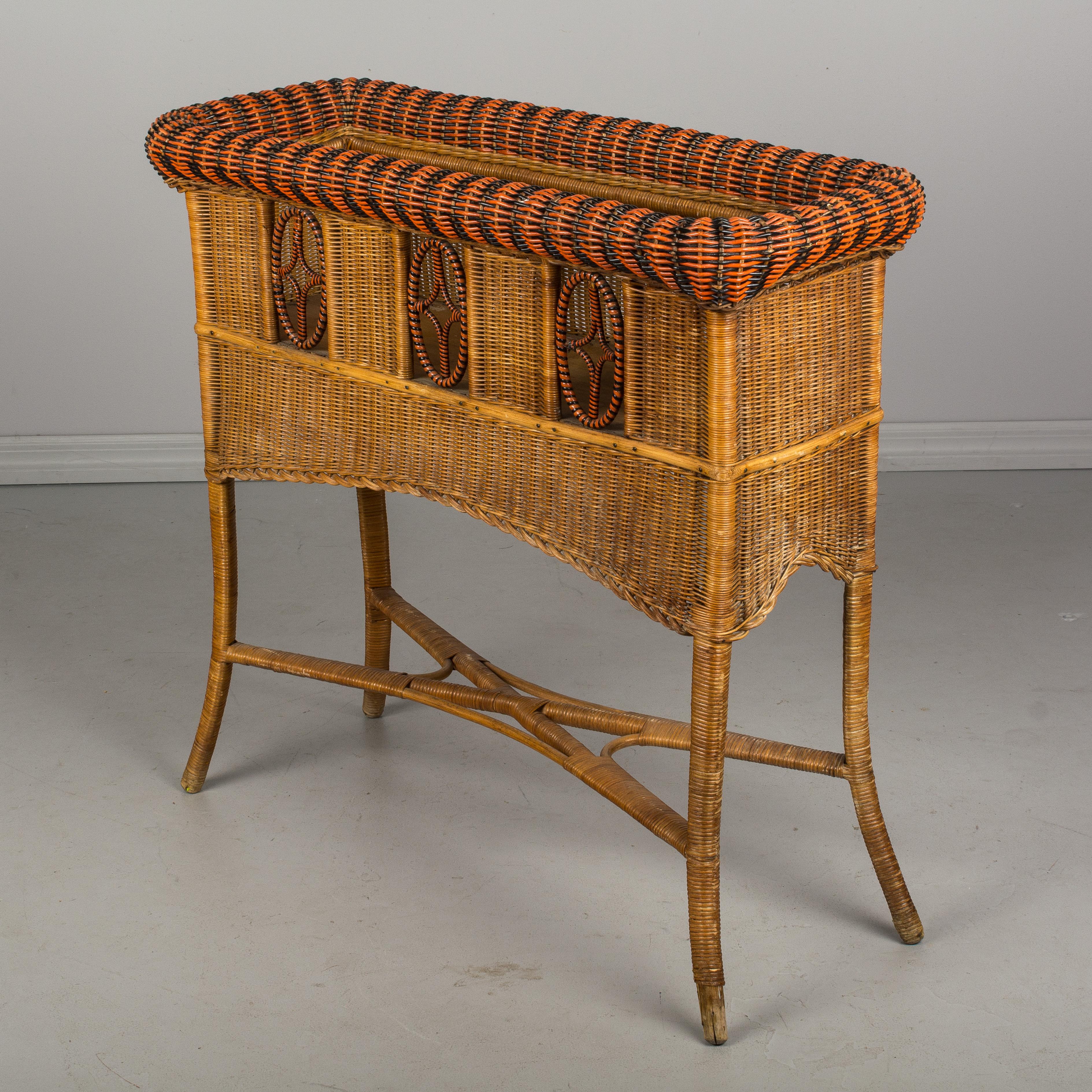 An early 20th century French woven wicker planter, or window box plant stand. Exceptional craftsmanship and design, having sturdy bamboo frame with x-pattern stretcher and tightly woven body with openwork details along the front. Excellent condition