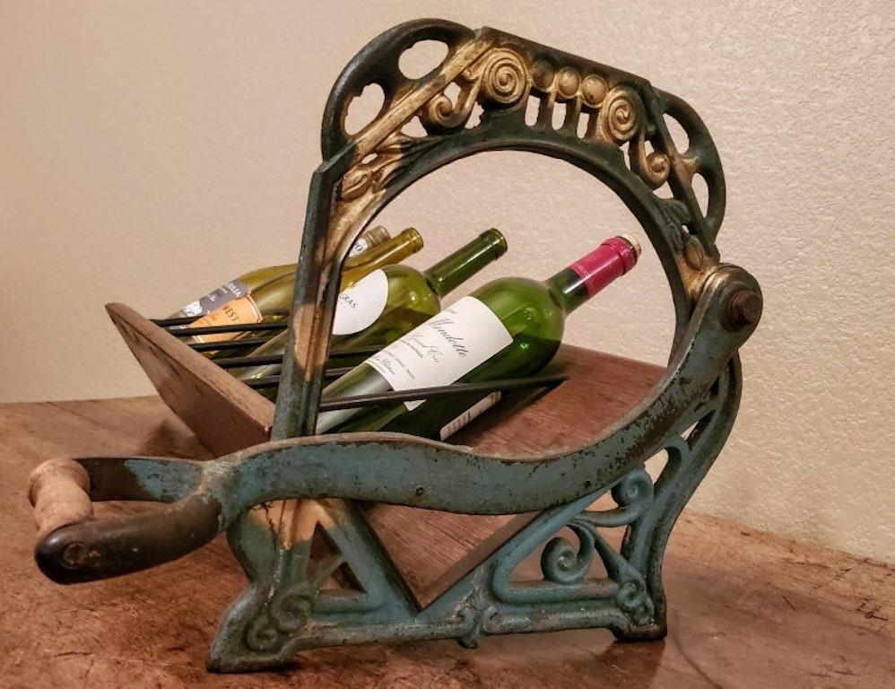 A beautiful, one-of-a-kind, 19th century French bakers cast iron and wood industrial bread slicer / cutter, with the blade removed, and fashioned into a countertop wine bottle rack / display with a capacity to hold up to seven bottles! 

The