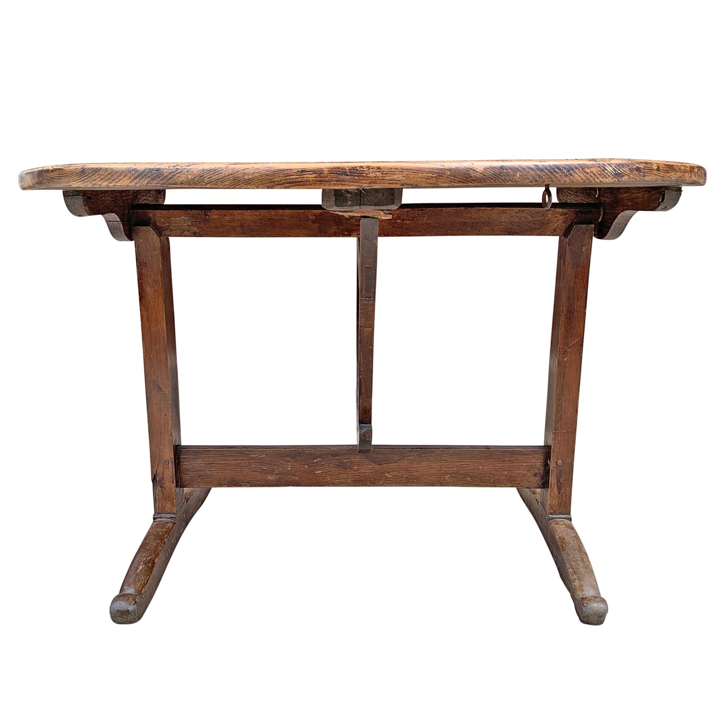 A wonderful 19th century French tilt-top wine tasting table with a beautifully figural pine top with walnut legs and an oak rotating support. Tables like these were historically used on French vineyards for small meals and/or tasting wine, and were