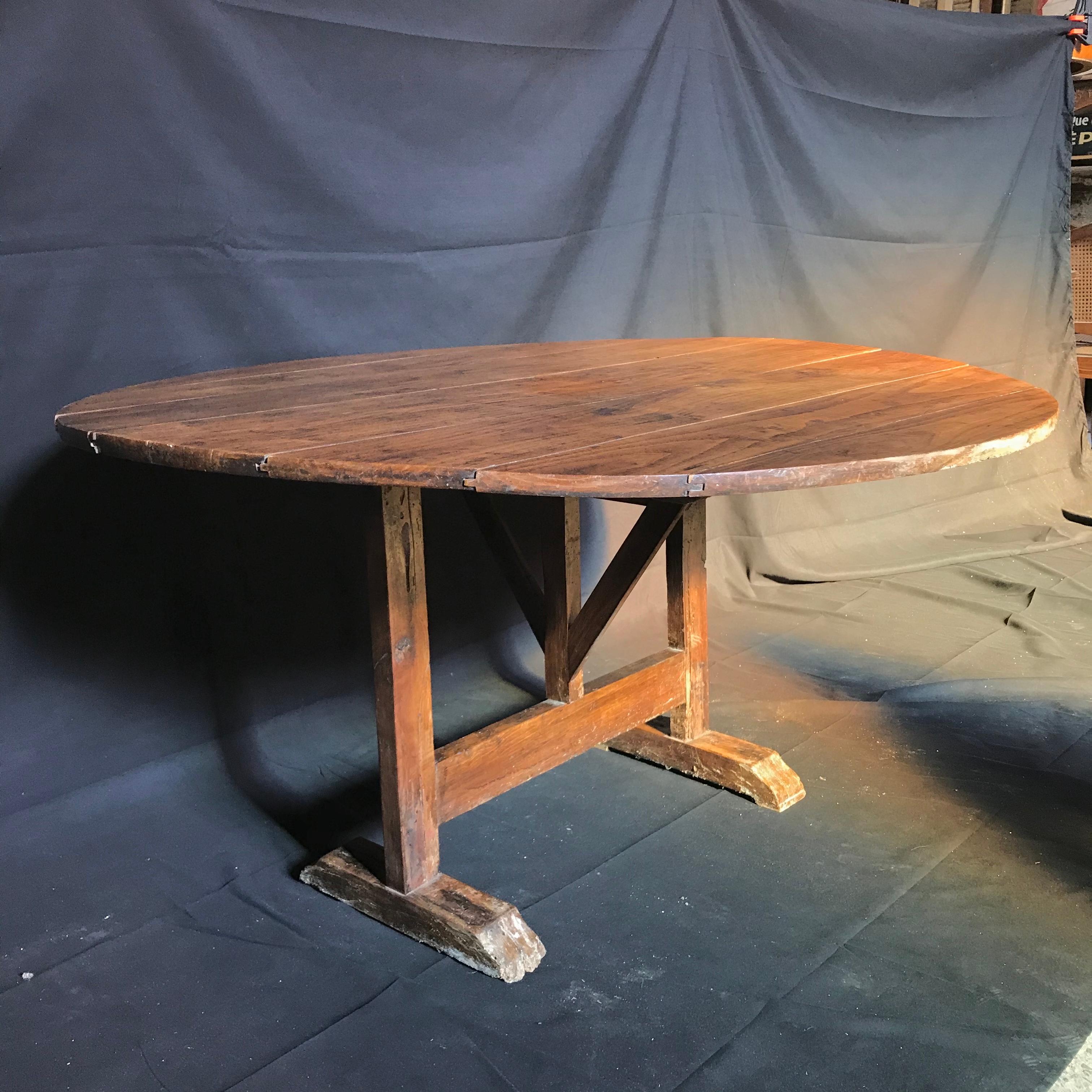 French wine tasting table, also known as a vendage or vigeron table, which was once used in the vineyards of France for tasting wine or enjoying a meal. This table would be suitable for use in a breakfast area or wine cellar. Featuring a tilt top,
