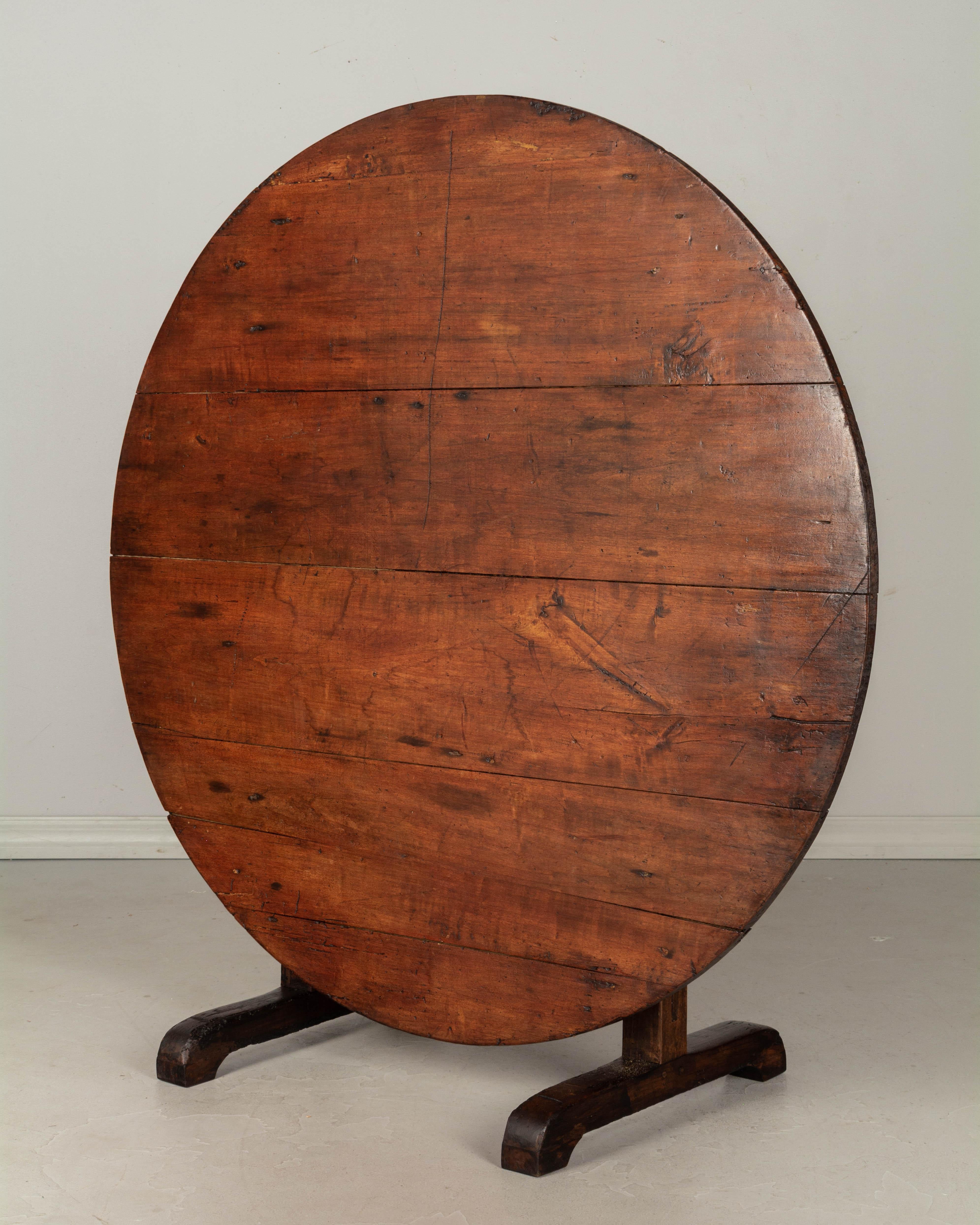 A 19th century French wine tasting, or tilt-top table with a top made of poplar and the base made of solid oak. Sturdy and well-crafted with mortise and tenon joints and pegged construction. This table was once covered with cloth. Waxed finish. The