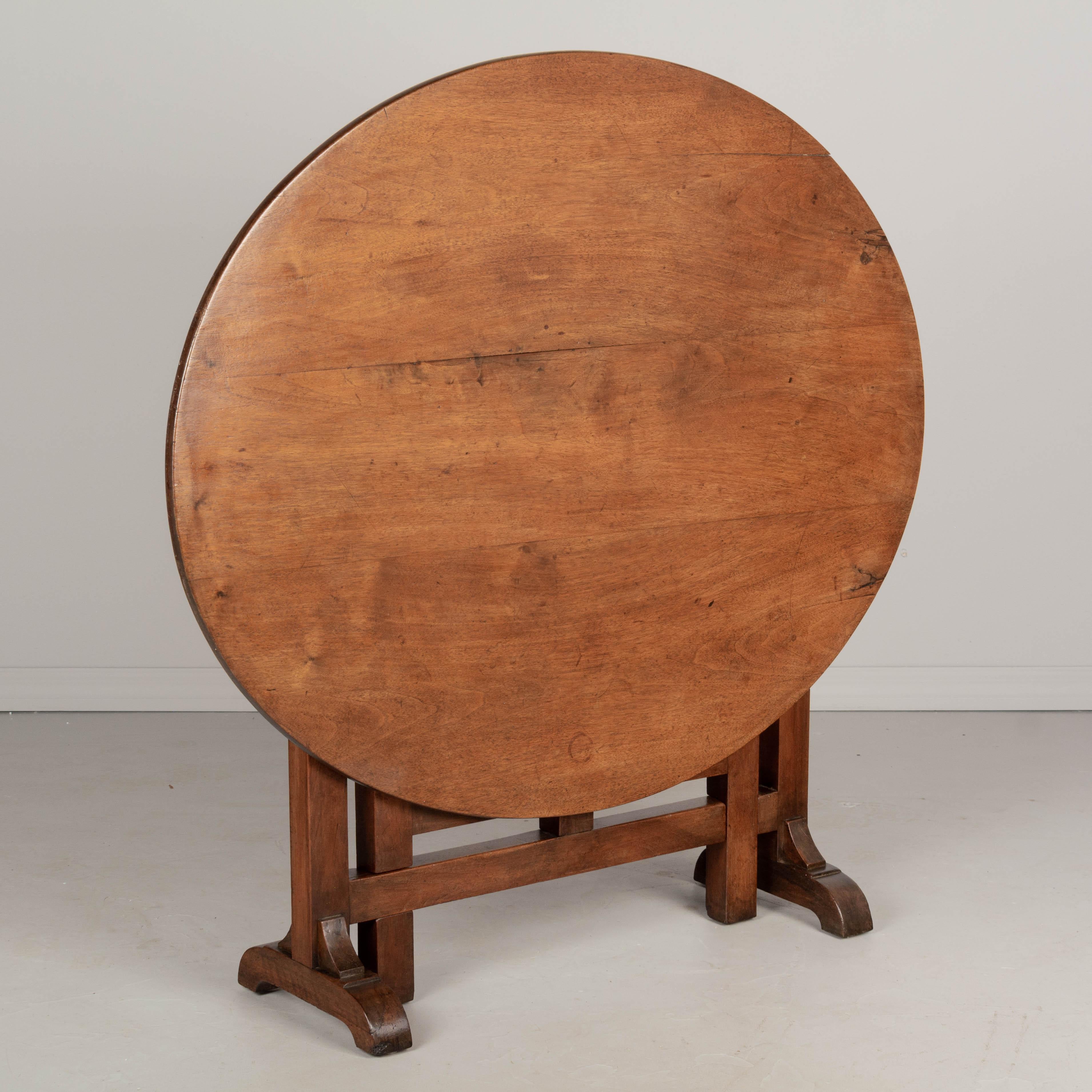 A 19th century French oval wine tasting, or tilt-top table made of solid walnut. The base is thick and sturdy. Well-crafted with mortise and tenon joints and pegged construction. Waxed finish. This table is a good height for use as a dining table