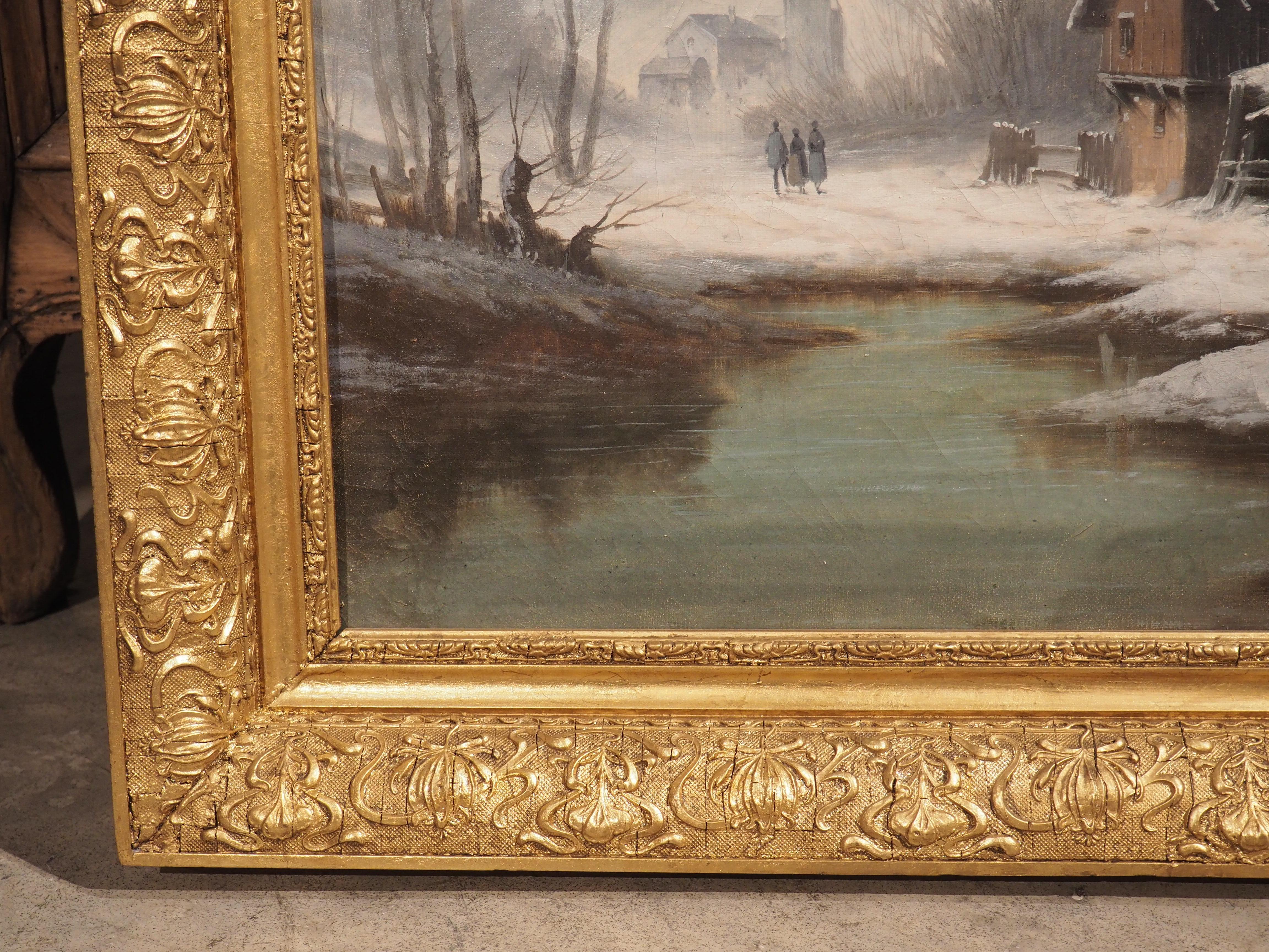 This French winter landscape painting from the 1800’s sits securely in the original giltwood frame. The hand-carved frame has several long ribbons, with sinuous fabric curls encompassing a repeating border of two distinct flowers. A slender cavetto