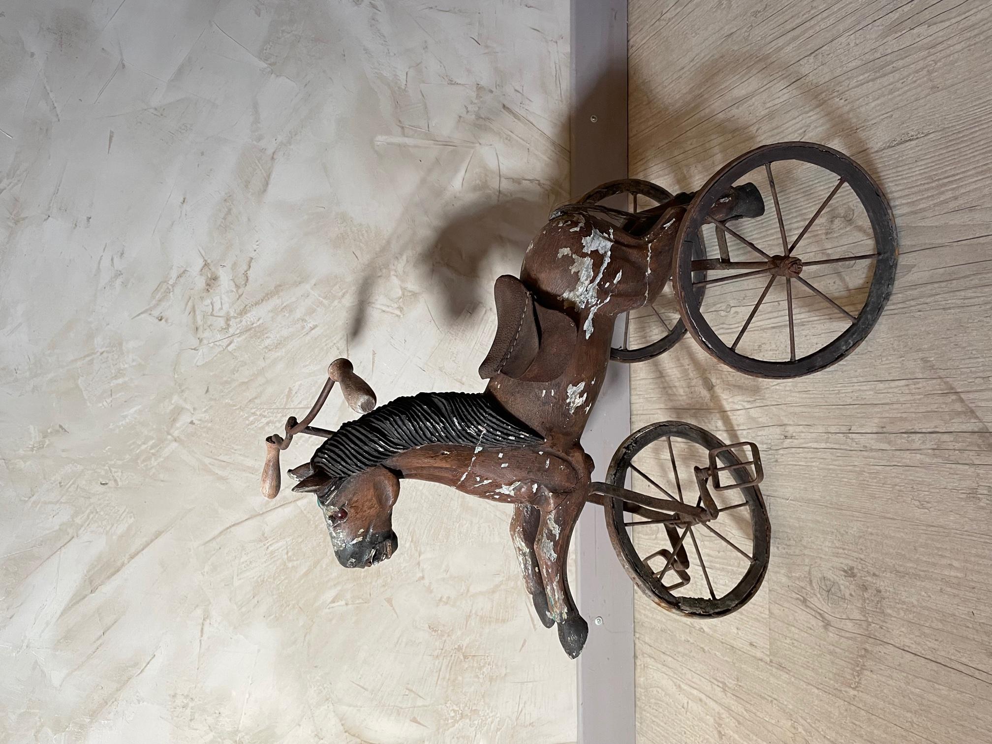 Beautiful 19th century French wood and iron child horse tricycle from the 1890s. 
The saddle is made with fabric. The painting has peeled off with the age and use. 
Nice quality.