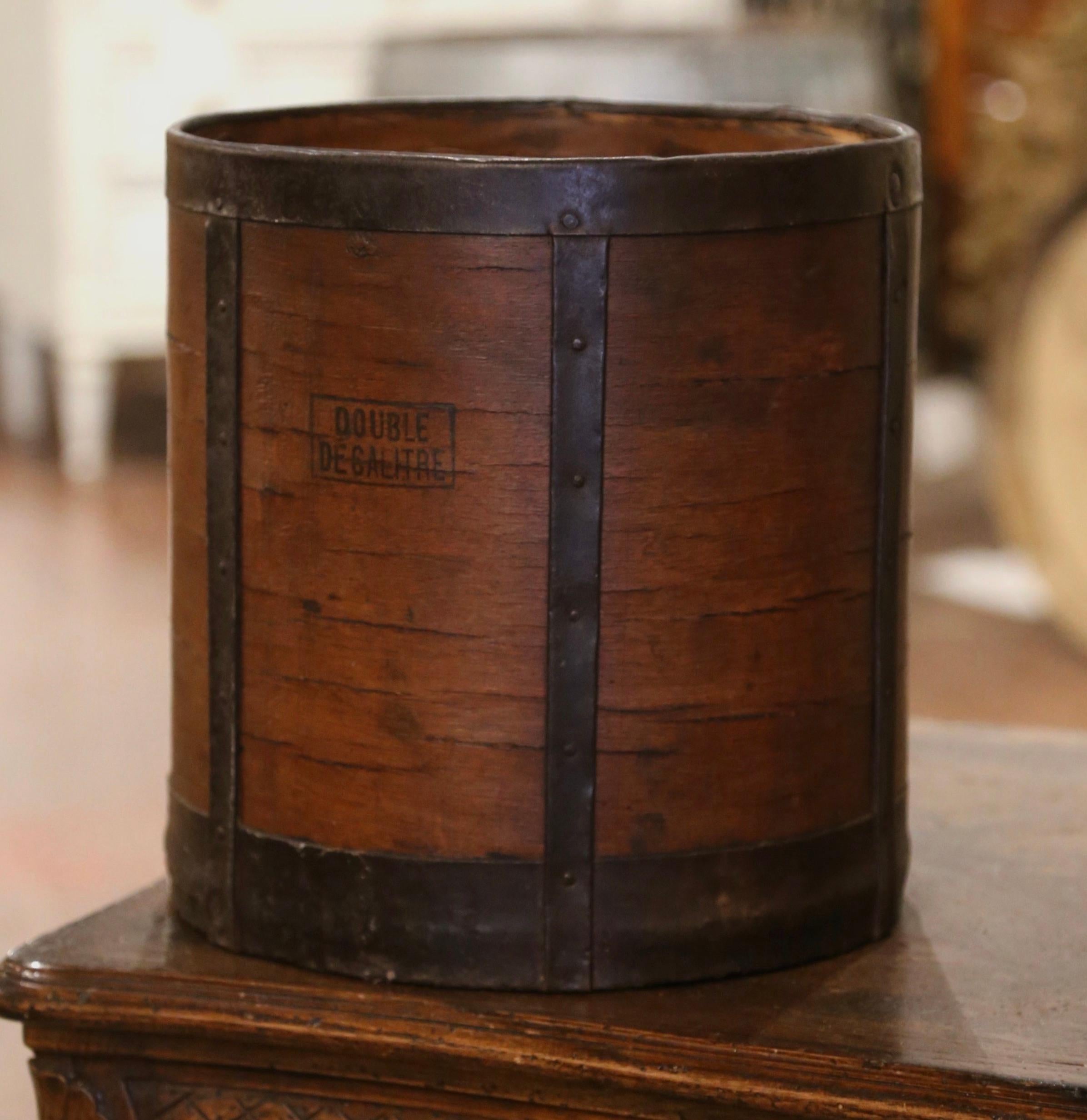 This antique grain measuring recipient was crafted in France, circa 1870. The bucket features metal straps, forged nails on the outside and an inside iron handle. The basket is printed 