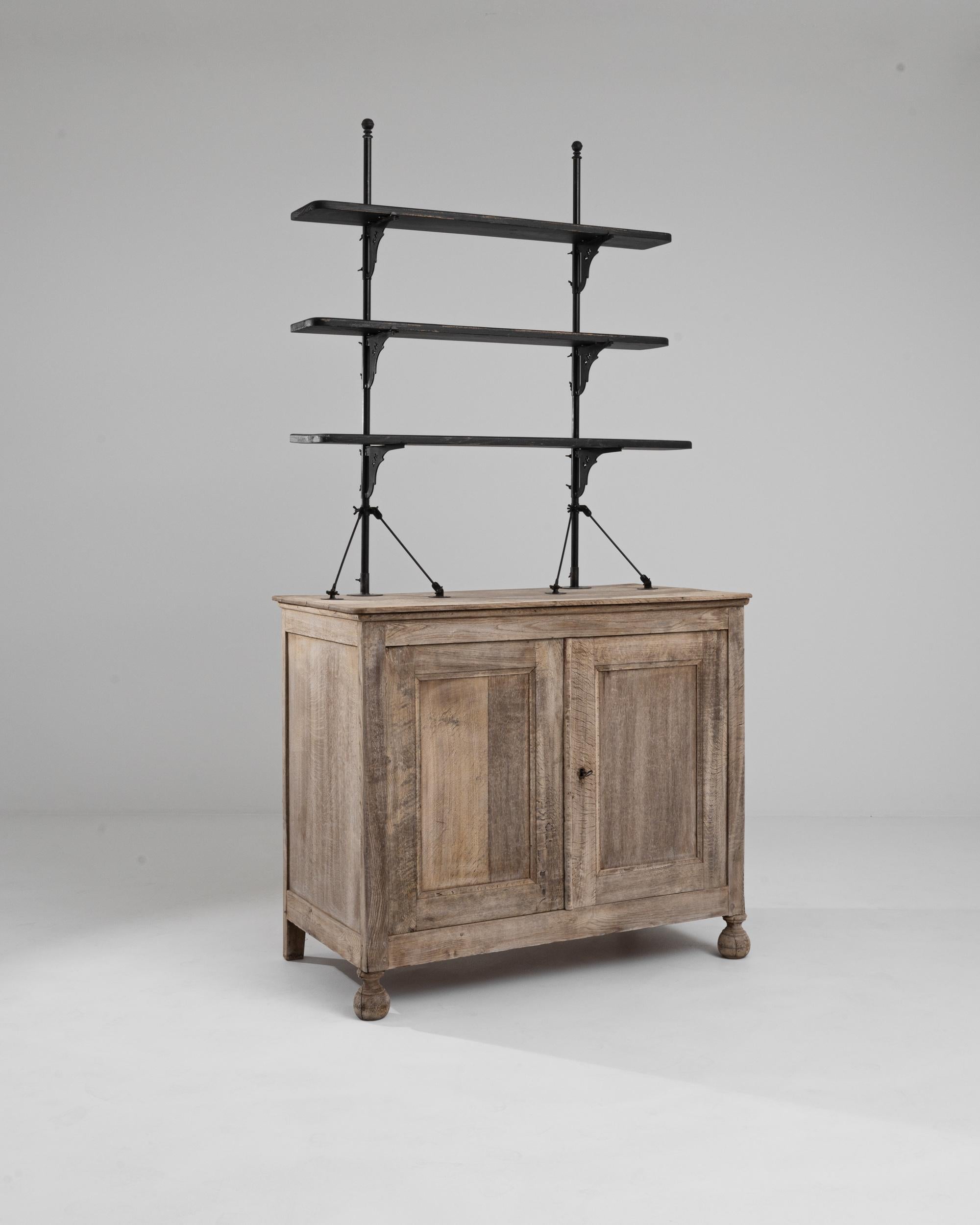 Made in France in the 19th century, this antique oak display cabinet offers a unique and practical silhouette. Three raised shelves are set upon slender metal posts to create an unobtrusive, pared-back open storage concept. The elegant shape of the