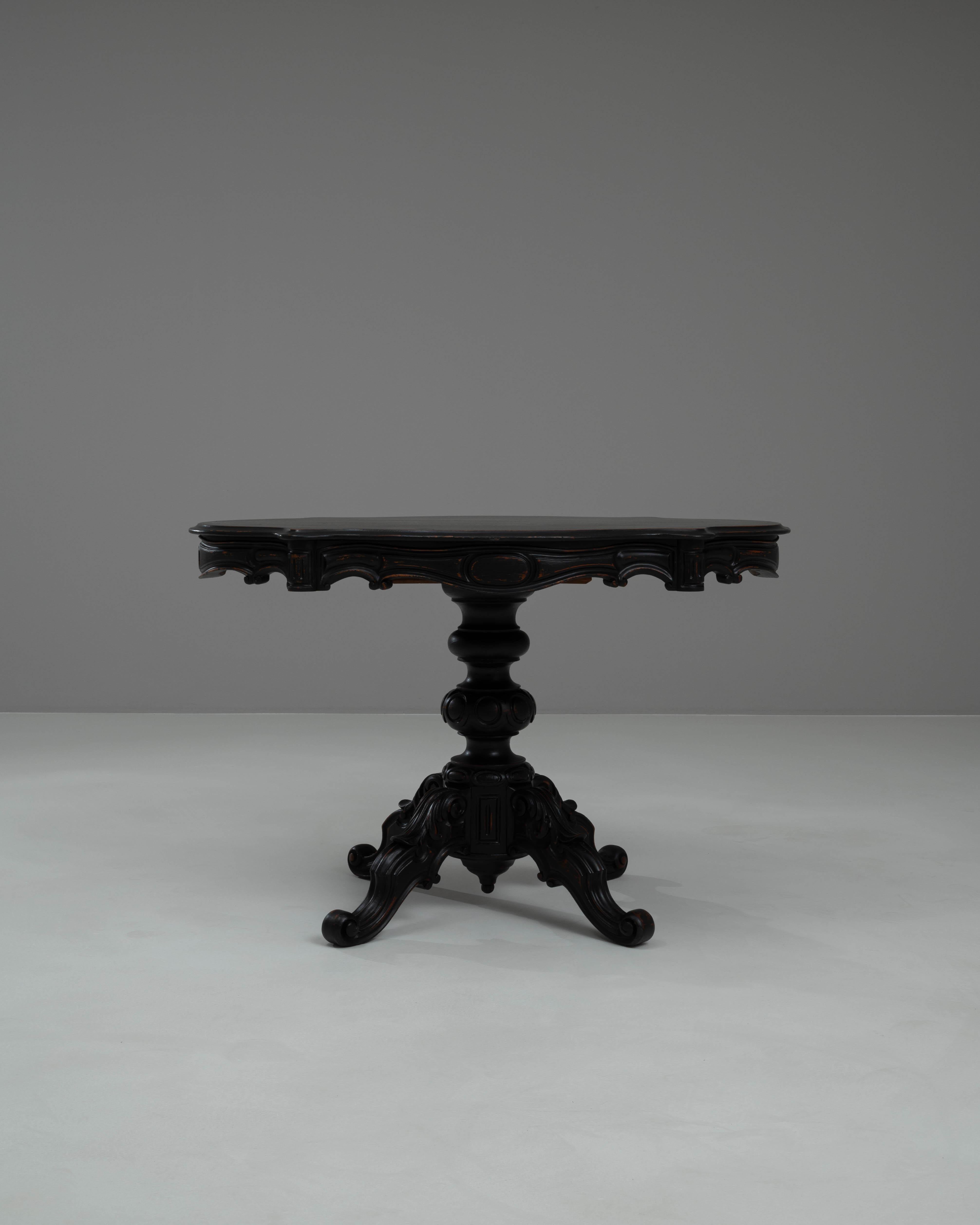 Cette magnifique table d'appoint en bois français du XIXe siècle patiné noir dégage une allure sophistiquée et mystérieuse qui captive toutes les pièces qu'elle orne. La finition noire profonde accentue magnifiquement les sculptures complexes et les