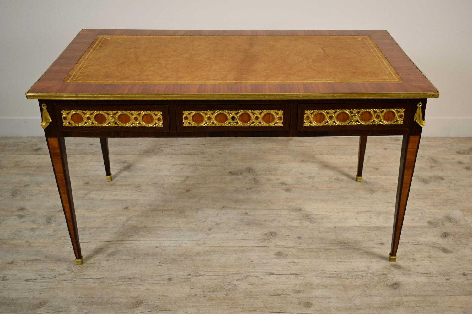 19th century French wood desk table with golden bronzes

The elegant desk table was made in France in the early nineteenth century. The structure is in paved wood decorated with gilt bronze applications. The top is covered in the middle with