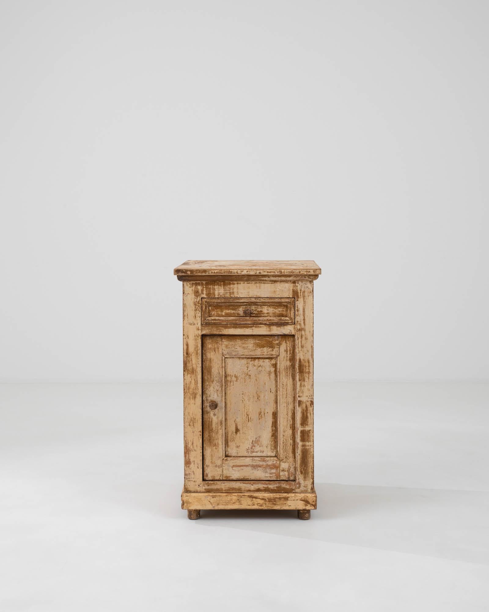 Remontez le temps avec cette authentique table de chevet en bois patiné français du XIXe siècle, une pièce qui capture véritablement l'essence du charme rustique. Chaque angle révèle la riche histoire de l'armoire, racontée à travers sa patine et