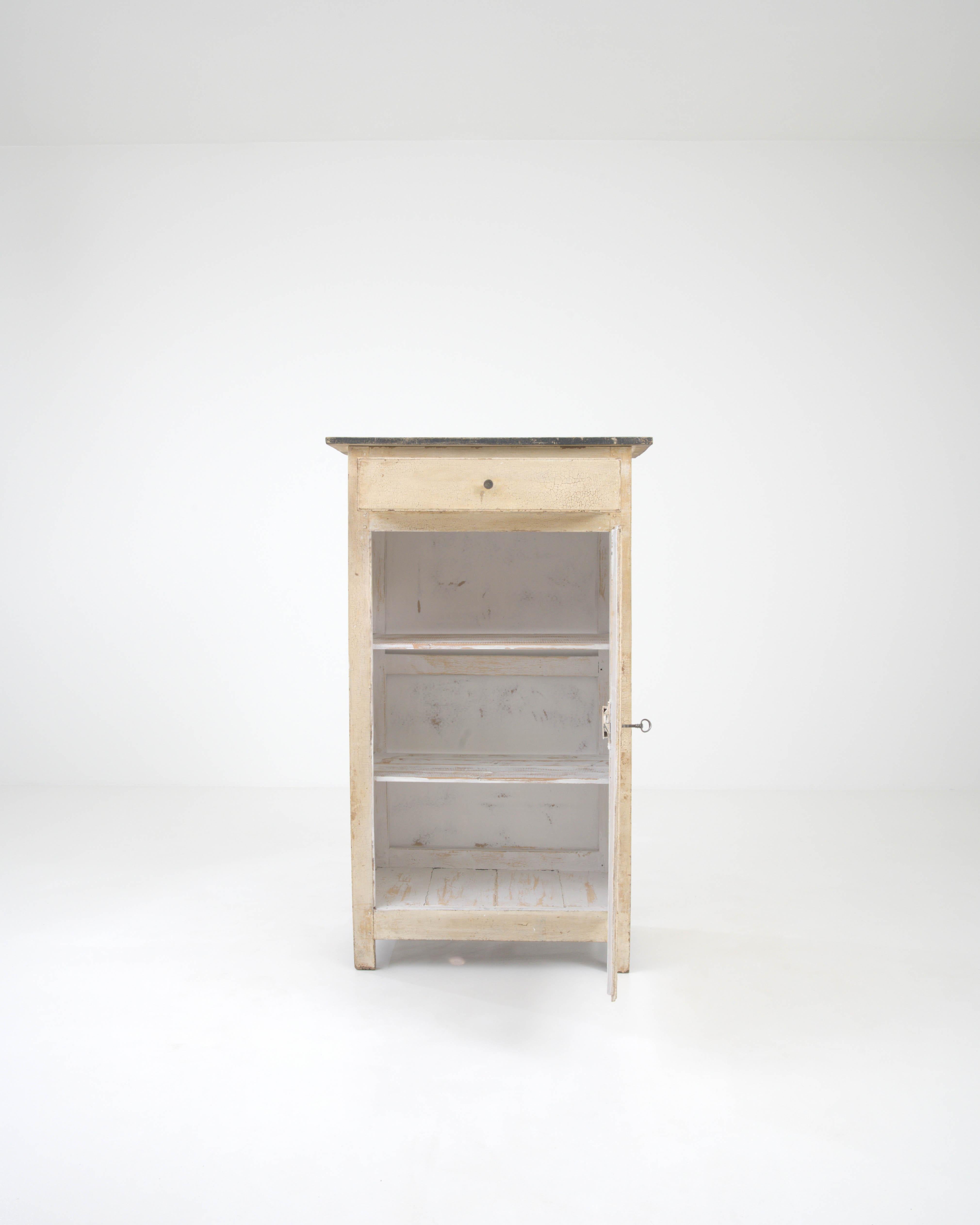 Discover the rustic charm of this 19th-century French cabinet, a piece that exudes character with its richly patinated wood and authentic crackle finish. The cabinet's compact dimensions reveal a thoughtful design, making it an ideal addition to
