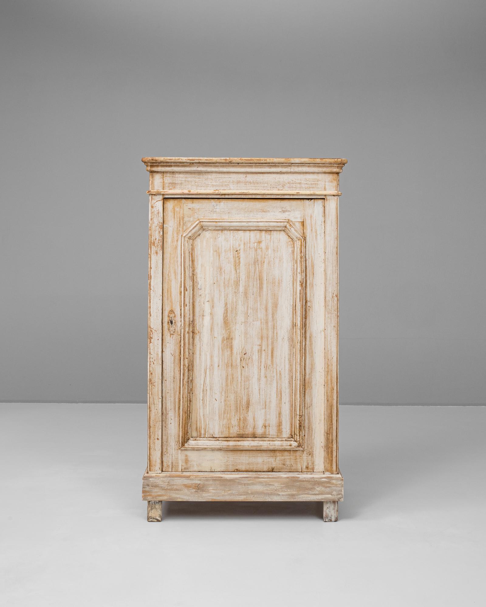 This elegant 19th-century French wood patinated cabinet exudes classic European craftsmanship with its beautifully distressed finish and ornate detailing. The solid wood construction showcases a naturally aged patina, adding character and warmth to