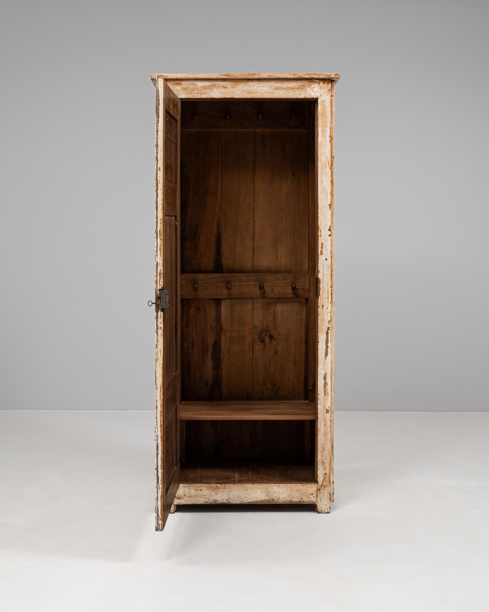 Realizzato nel XIX secolo, questo mobile francese in legno patinato incarna un'eleganza rustica con la sua finitura naturale e le sue proporzioni classiche. La porta a pannello singolo presenta una patina splendidamente invecchiata, che rivela