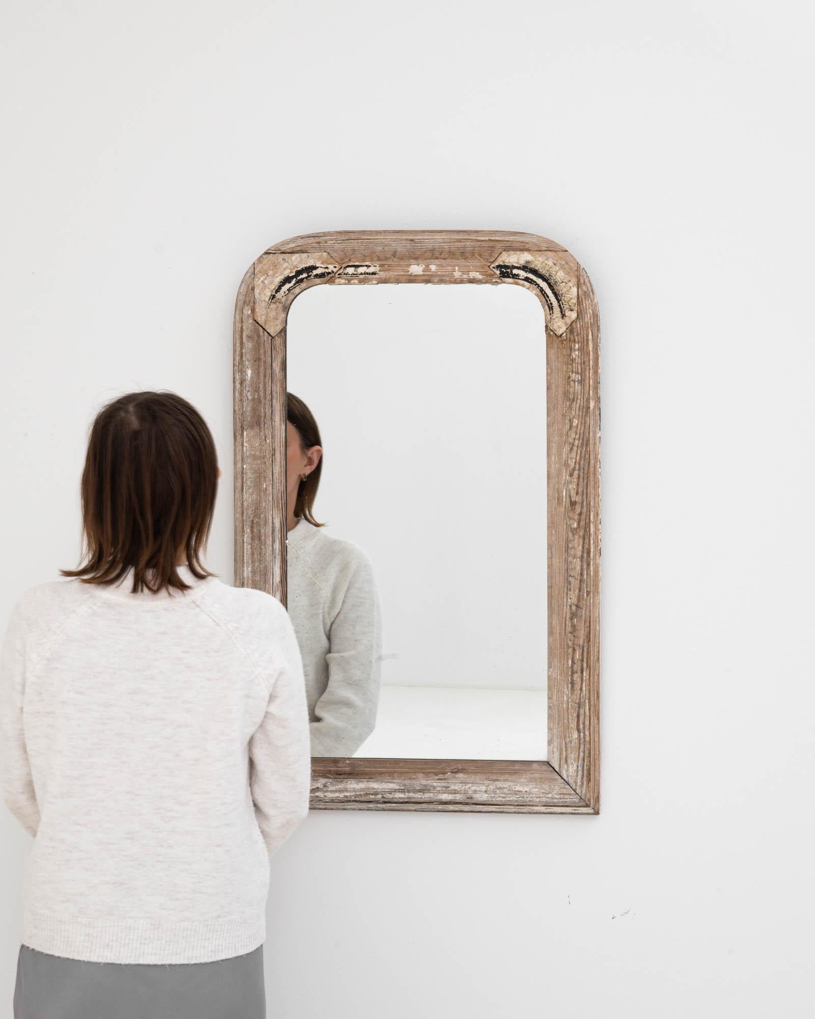 Step back in time and infuse your space with a sense of history with this 19th Century French Wood Patinated Mirror. Each glance offers more than just a reflection; it's a glimpse into a bygone era, framed by the weathered beauty of its rich wooden