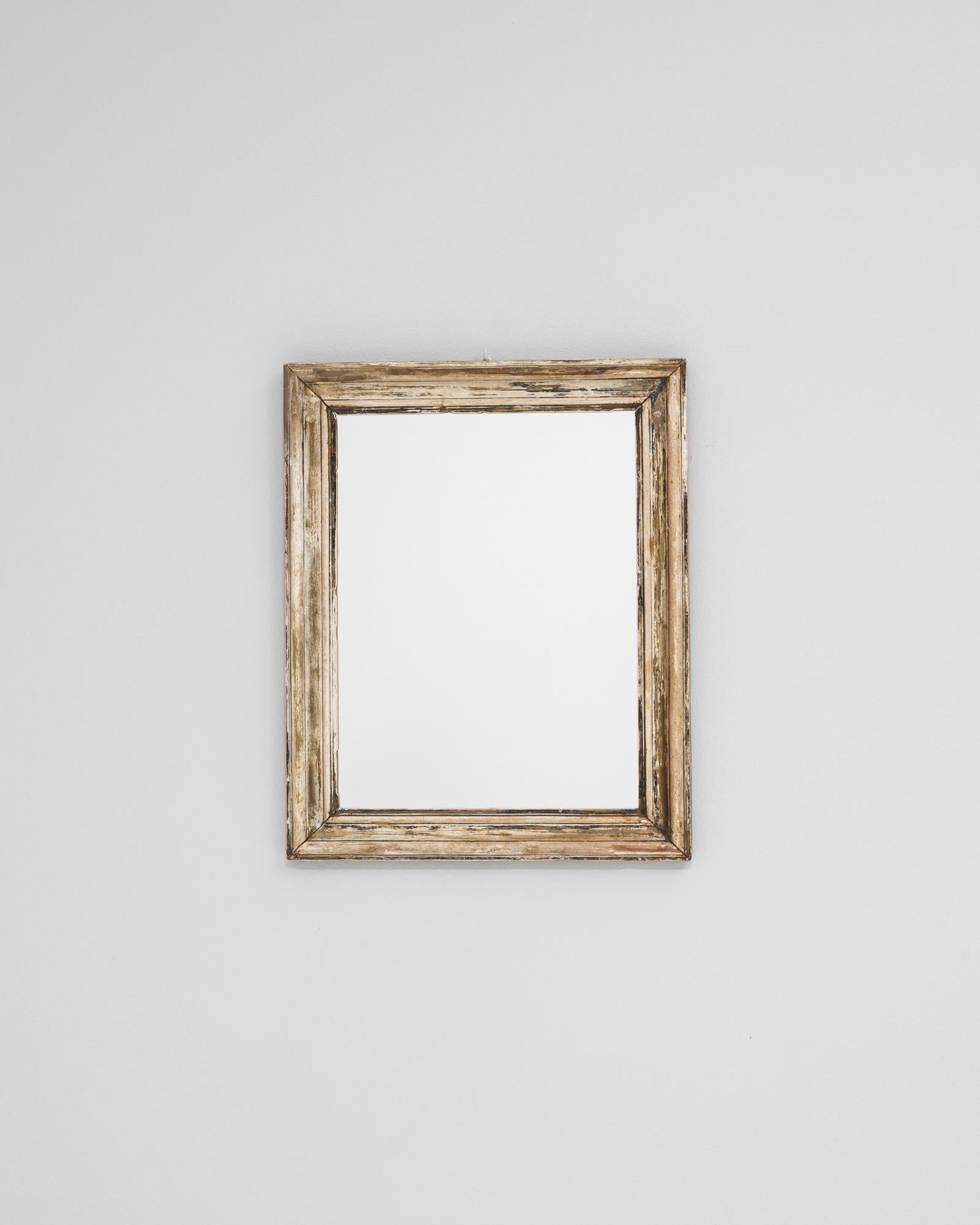 This 19th-century French mirror features a beautifully aged wooden frame with an authentic patinated finish that reveals layers of time and craftsmanship. The simple yet elegant molding highlights the natural wear and subtle traces of gilt, creating