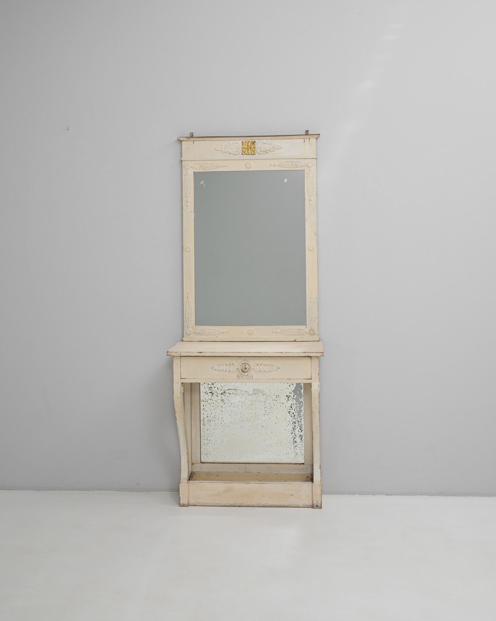 Este tocador francés de madera patinada en blanco del siglo XIX presenta líneas elegantes, delicadas tallas y un acabado suavemente envejecido que resalta su auténtico encanto de época. El espejo superior presenta motivos florales y de trigo