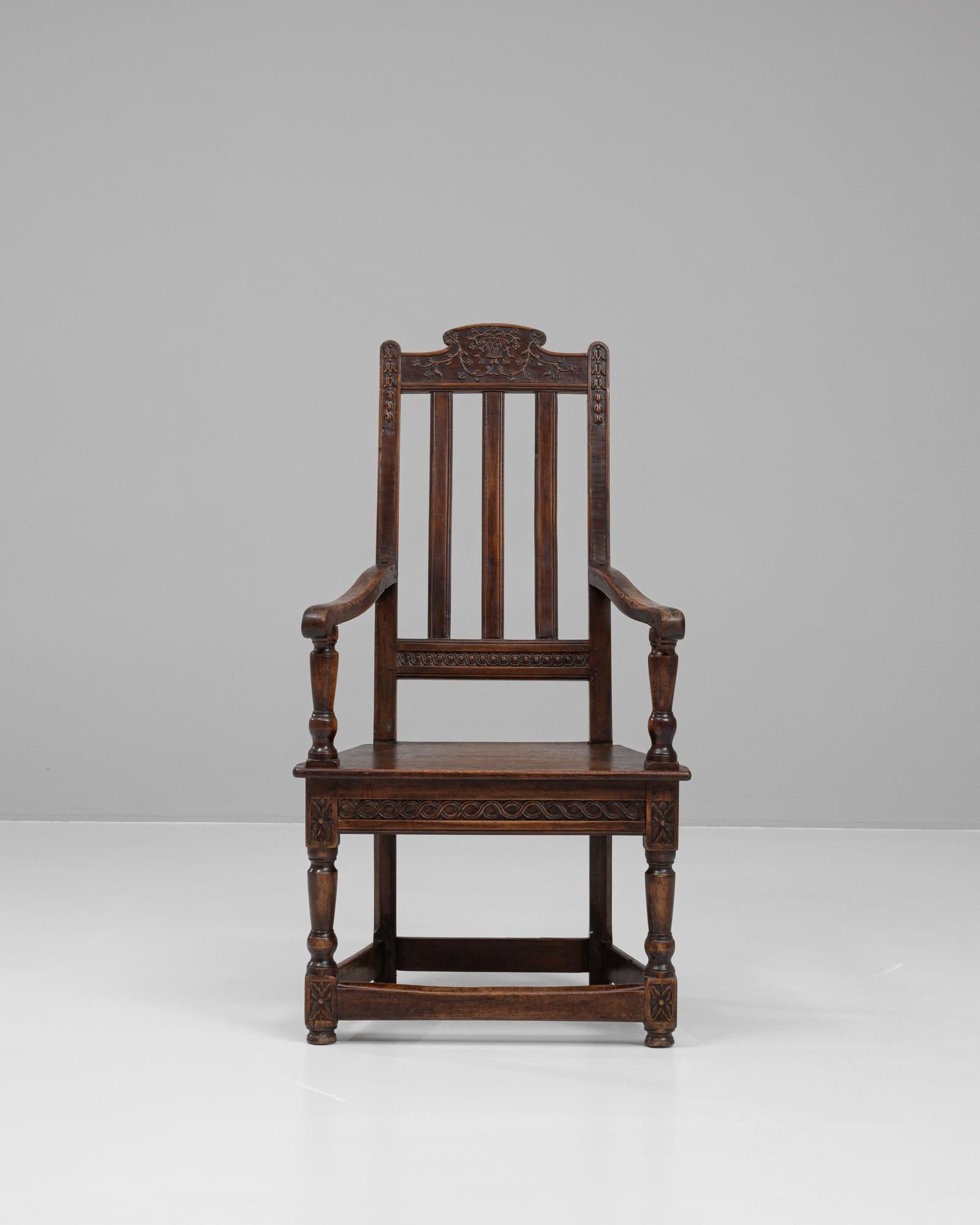 This 19th-century French wooden armchair is a fine example of traditional craftsmanship and timeless elegance. Made from solid wood, the chair features intricate hand-carved detailing on the crest rail and seat apron, adding a refined touch to its