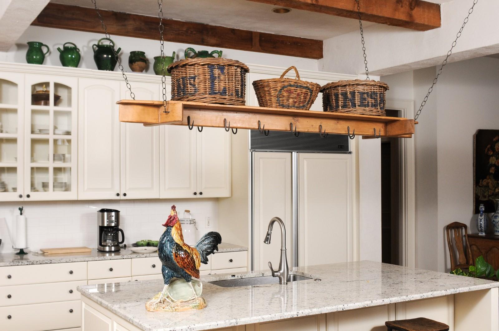 A French rustic pot rack from the 19th century, with iron hooks. Created in France during the 19th century, this pot rack, which used to be a bacon rack, features a polygonal wooden structure, supporting a regular rhythm of iron hooks perfect to