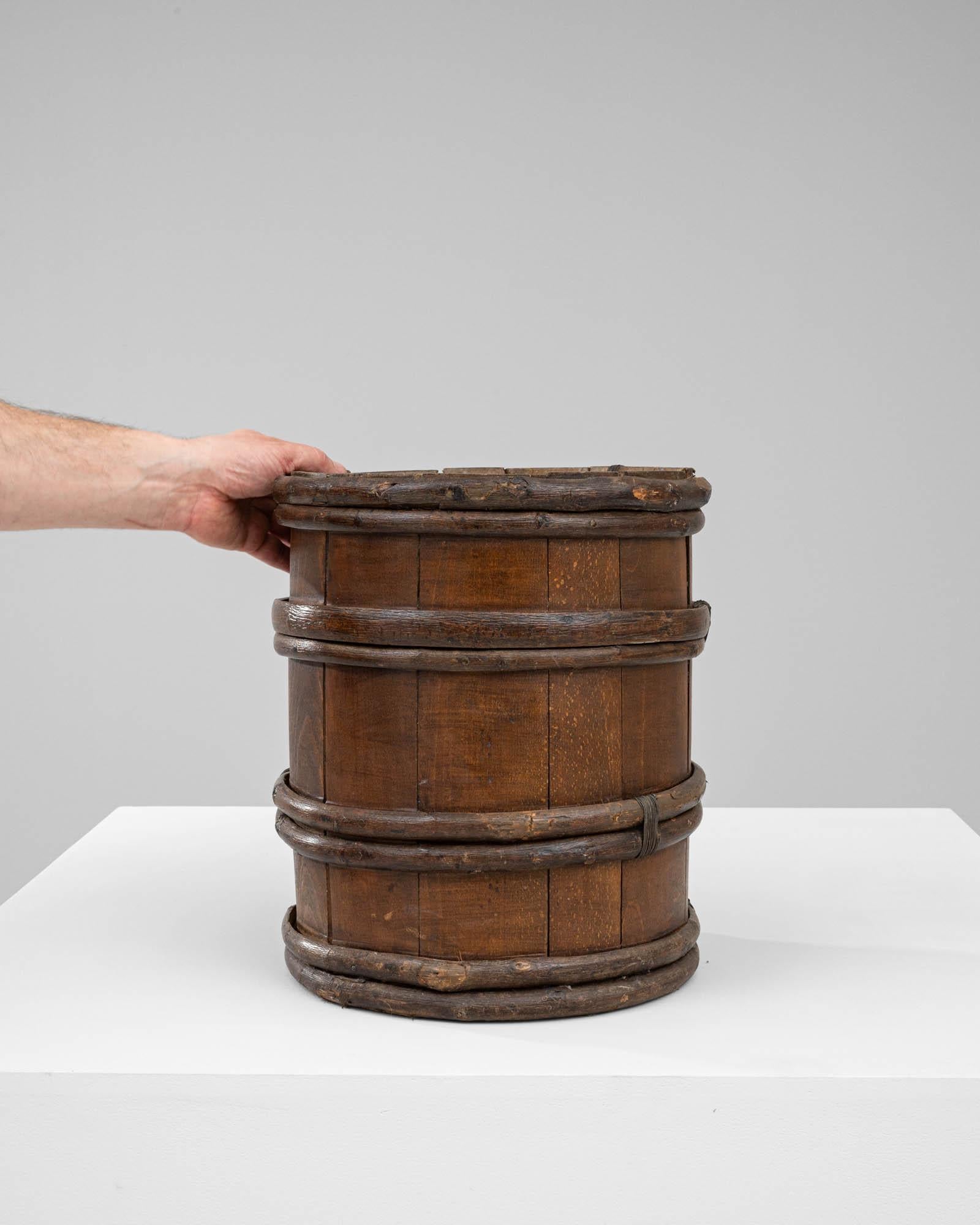 This 19th Century French Wooden Barrel evokes nostalgia for a time when craftsmanship and rustic elegance were paramount. Crafted with precision and care, its petite size reminiscent of a cup, this barrel carries with it the charm of yesteryears.