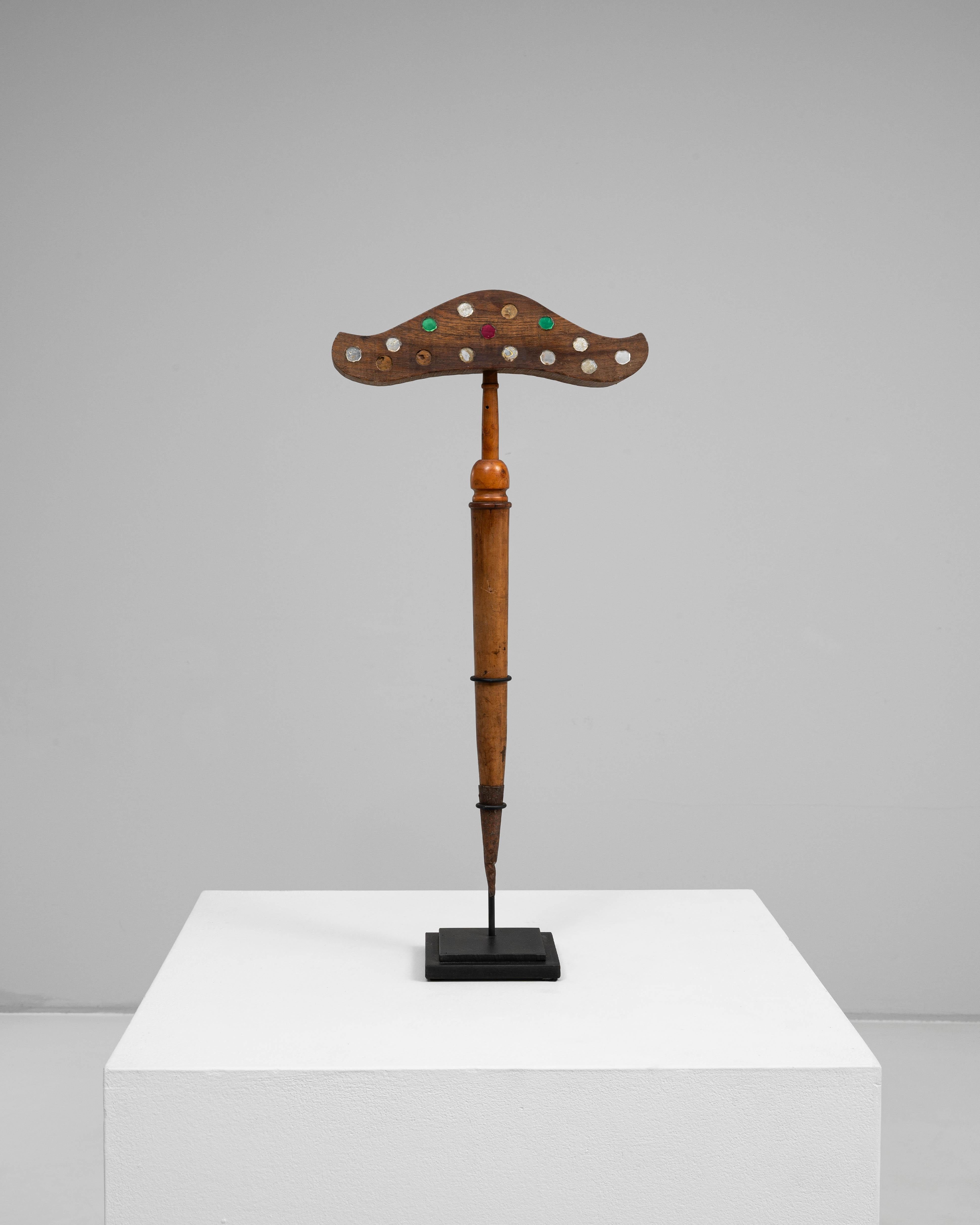 Questa esca per uccelli in legno francese del XIX secolo cattura l'arte e l'ingegno dell'artigianato rurale. Scolpito a mano con una forma dolcemente ricurva che ricorda un uccello in volo, è impreziosito da intarsi colorati dipinti in rosso, verde