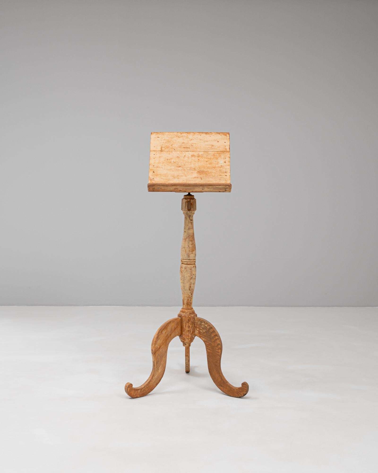 Questo leggio in legno francese del XIX secolo mostra una notevole abilità artigianale con una patina splendidamente invecchiata che ne esalta la forma scultorea. La base a treppiede presenta gambe elegantemente ricurve e una colonna centrale